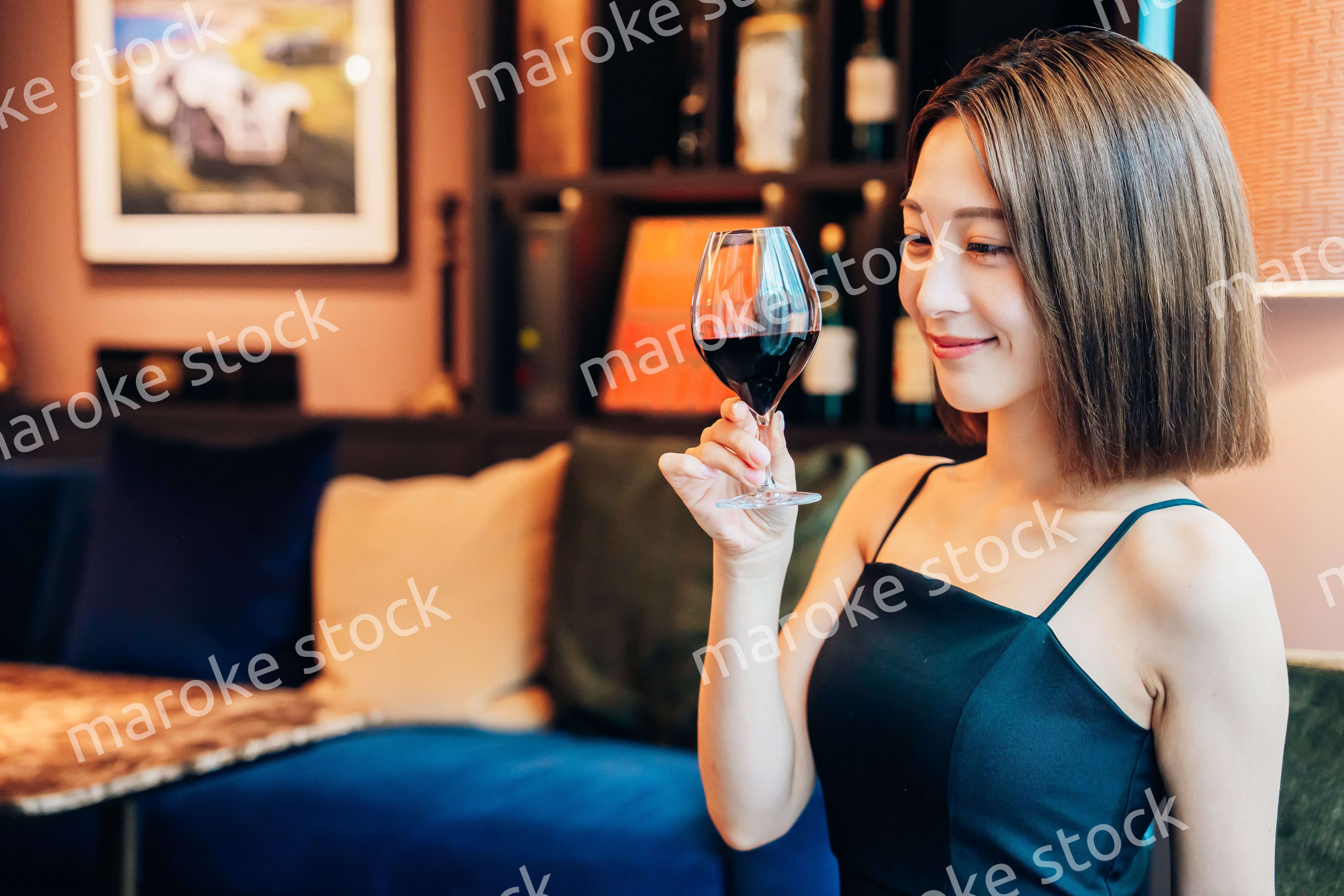 ラグジュアリーな雰囲気のお店で赤ワインを飲む若い女性