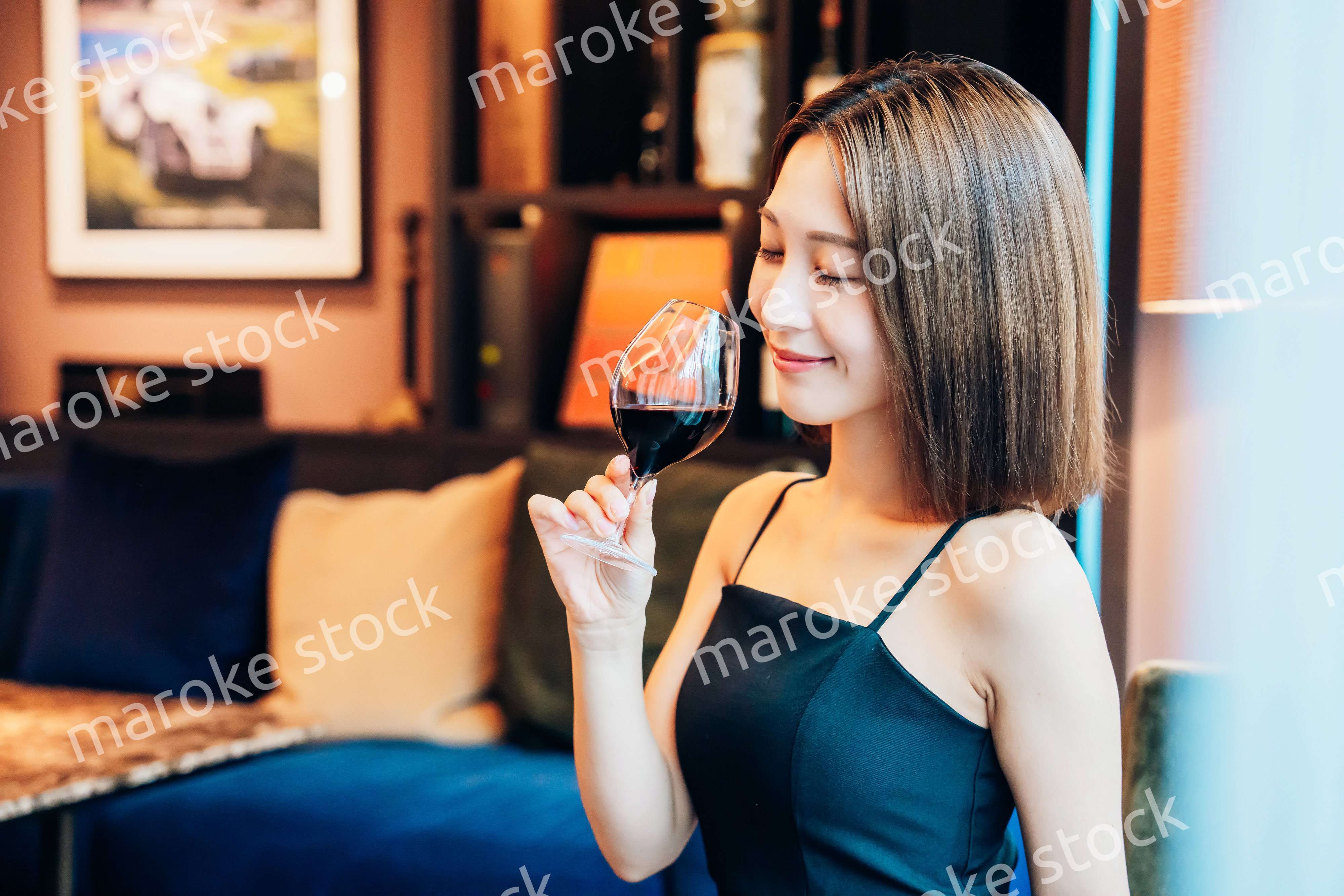 ラグジュアリーな雰囲気のお店で赤ワインを飲む若い女性