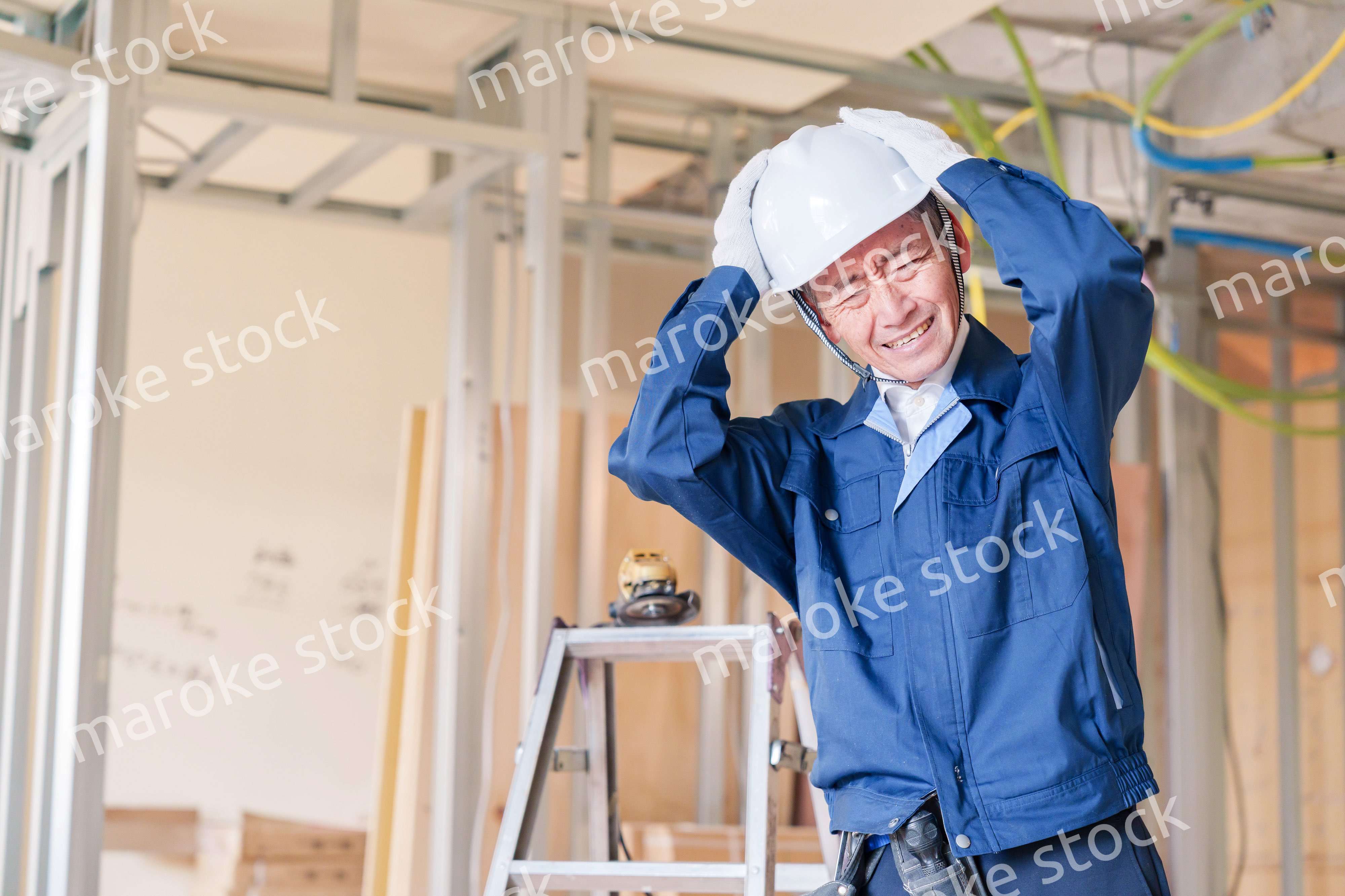 現場で頭を抱える男性の大工