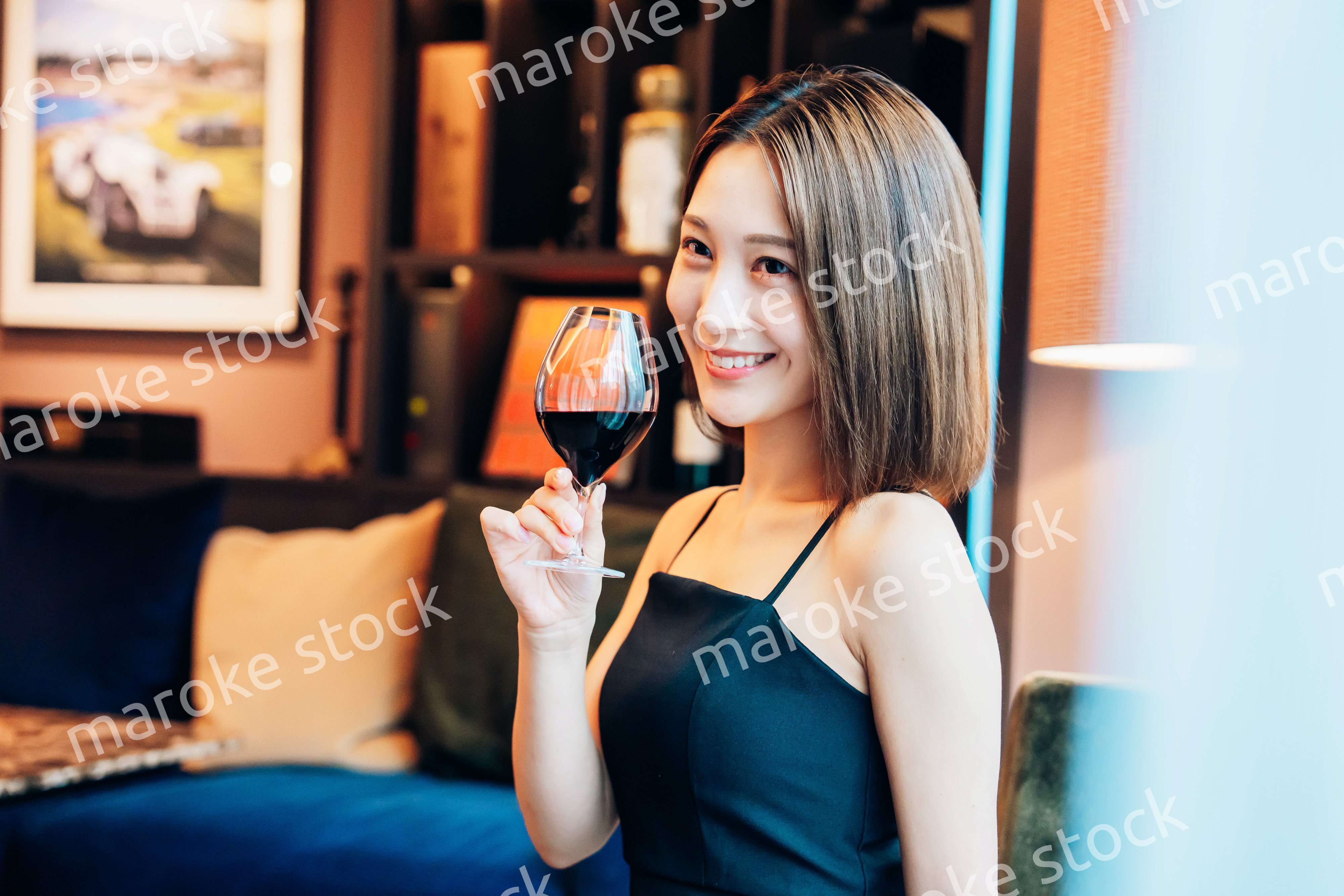 ラグジュアリーな雰囲気のお店で赤ワインを飲む若い女性