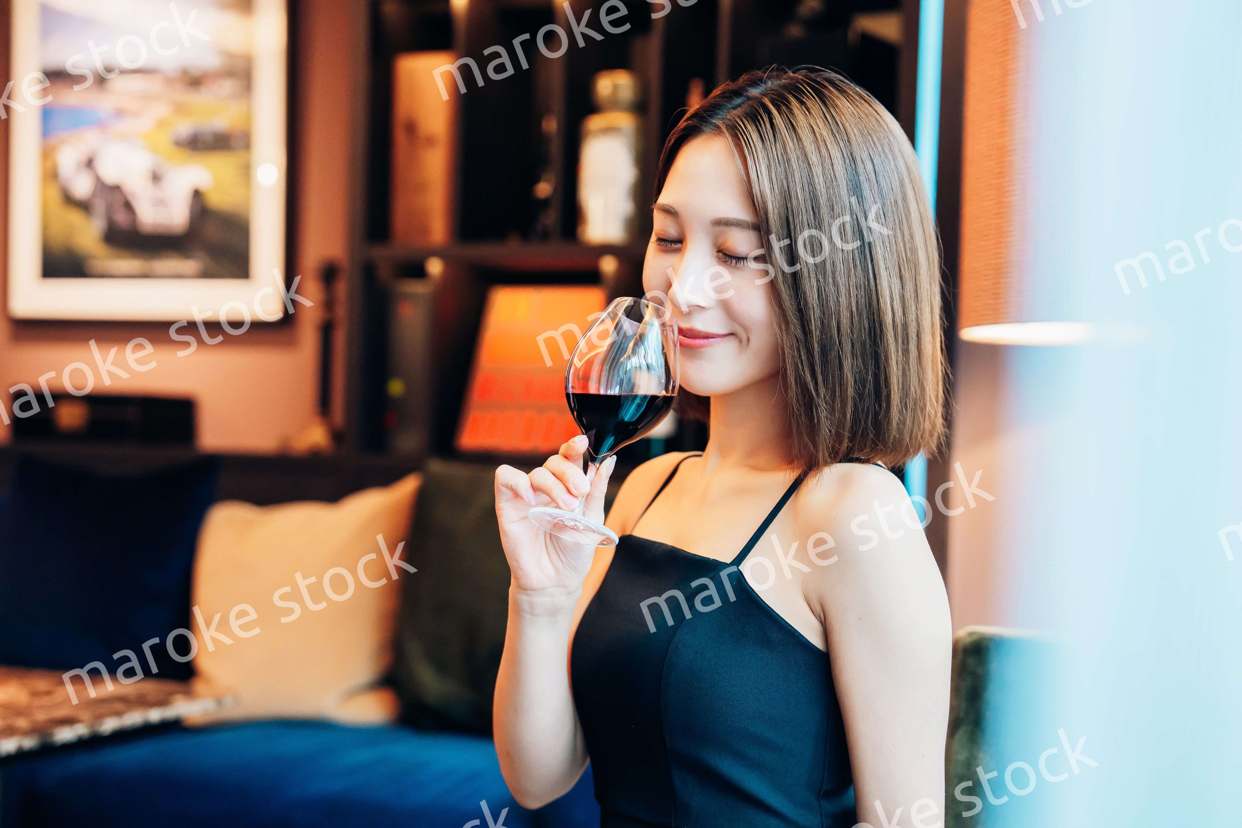 ラグジュアリーな雰囲気のお店で赤ワインを飲む若い女性