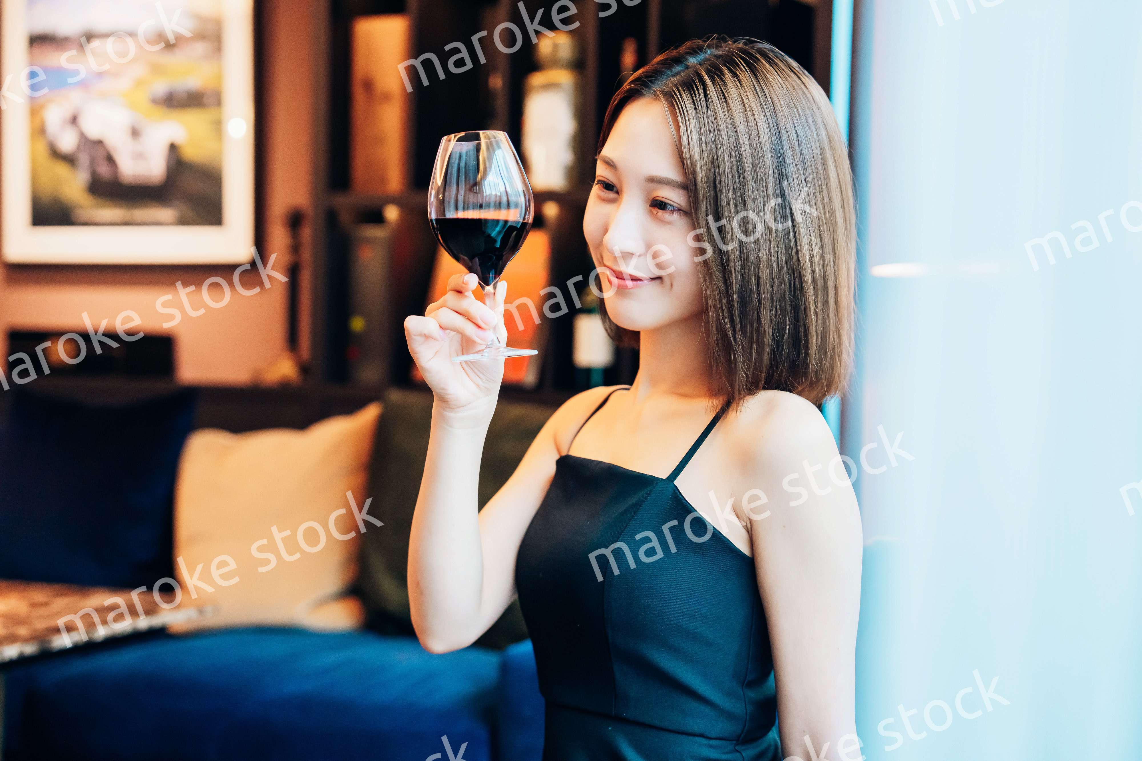 ラグジュアリーな雰囲気のお店で赤ワインを飲む若い女性