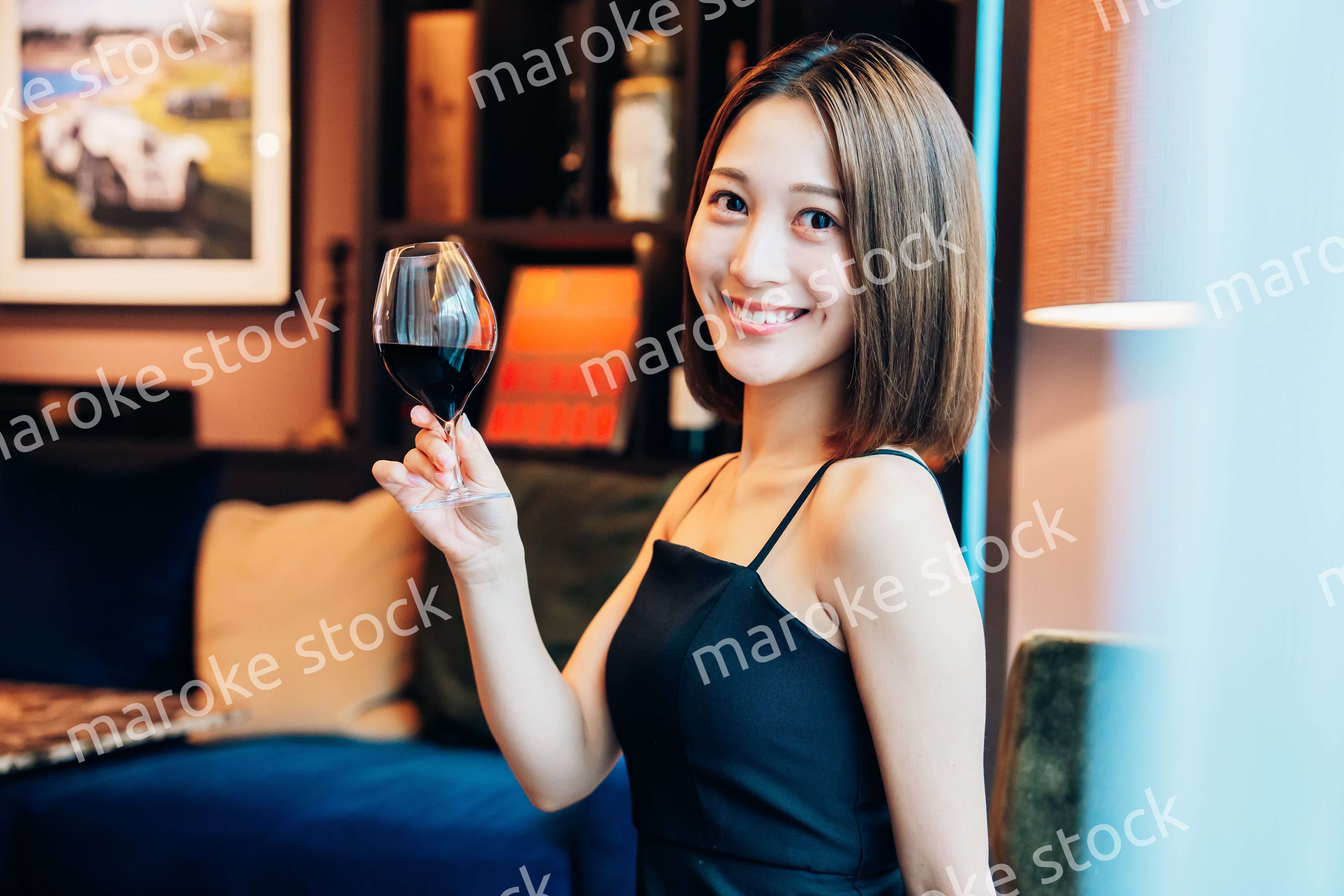 ラグジュアリーな雰囲気のお店で赤ワインを飲む若い女性