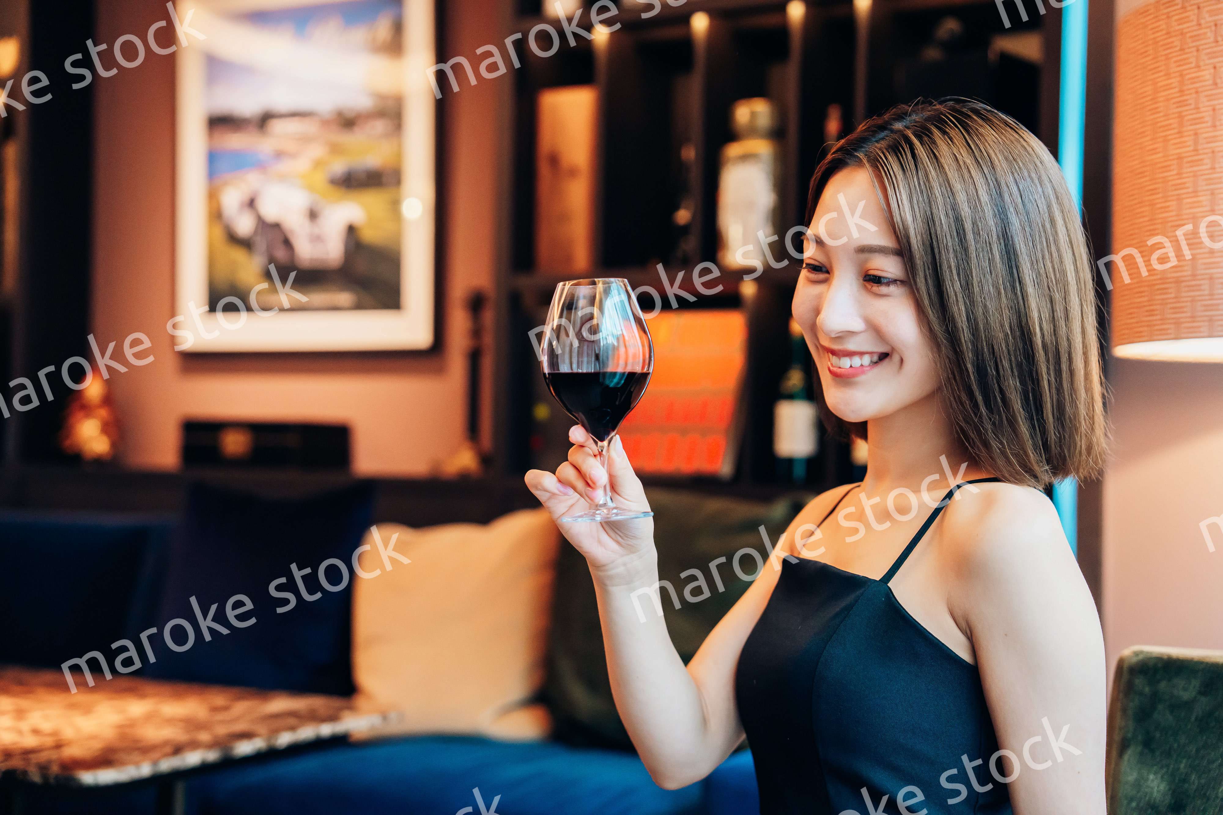 ラグジュアリーな雰囲気のお店で赤ワインを飲む若い女性