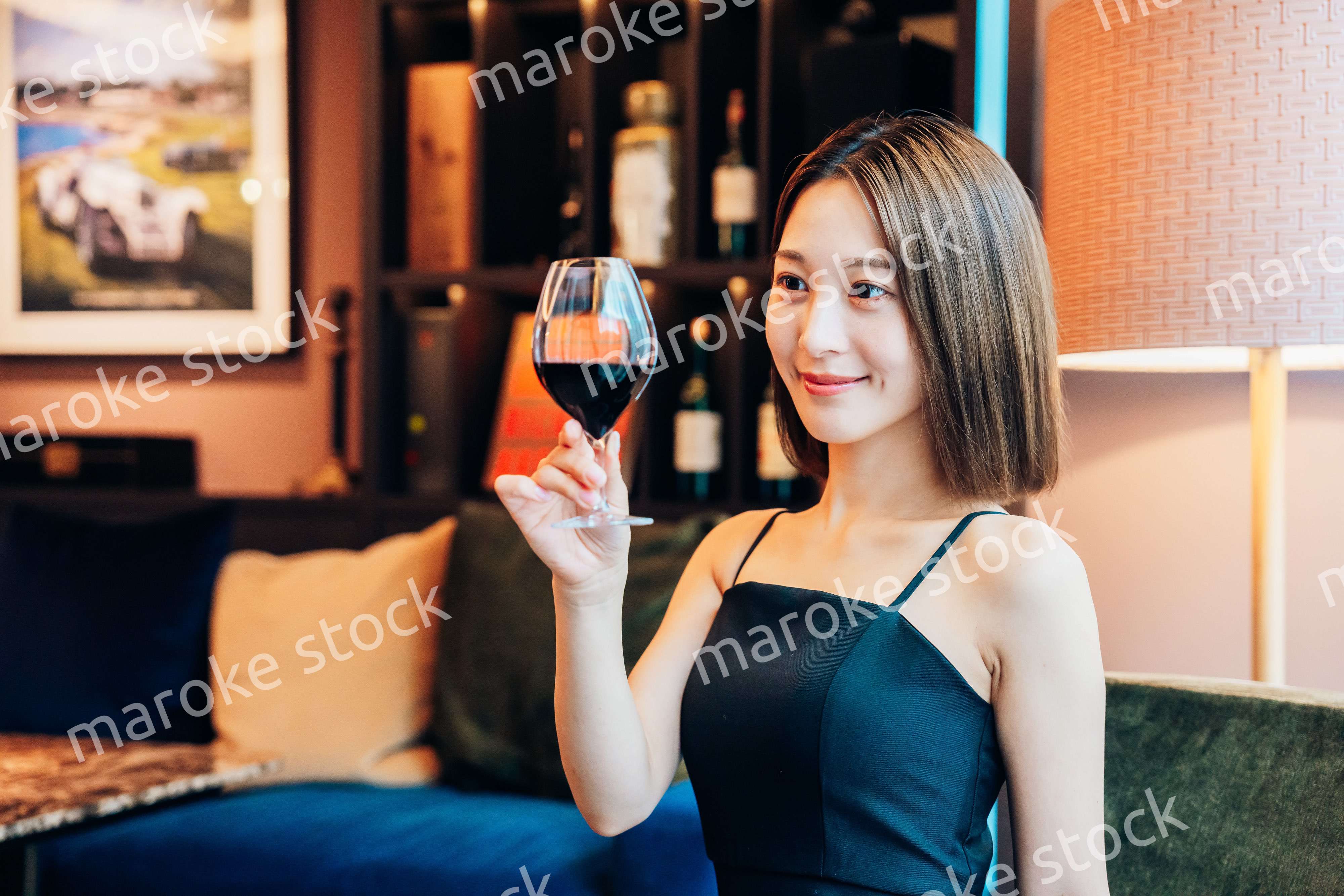 ラグジュアリーな雰囲気のお店で赤ワインを飲む若い女性