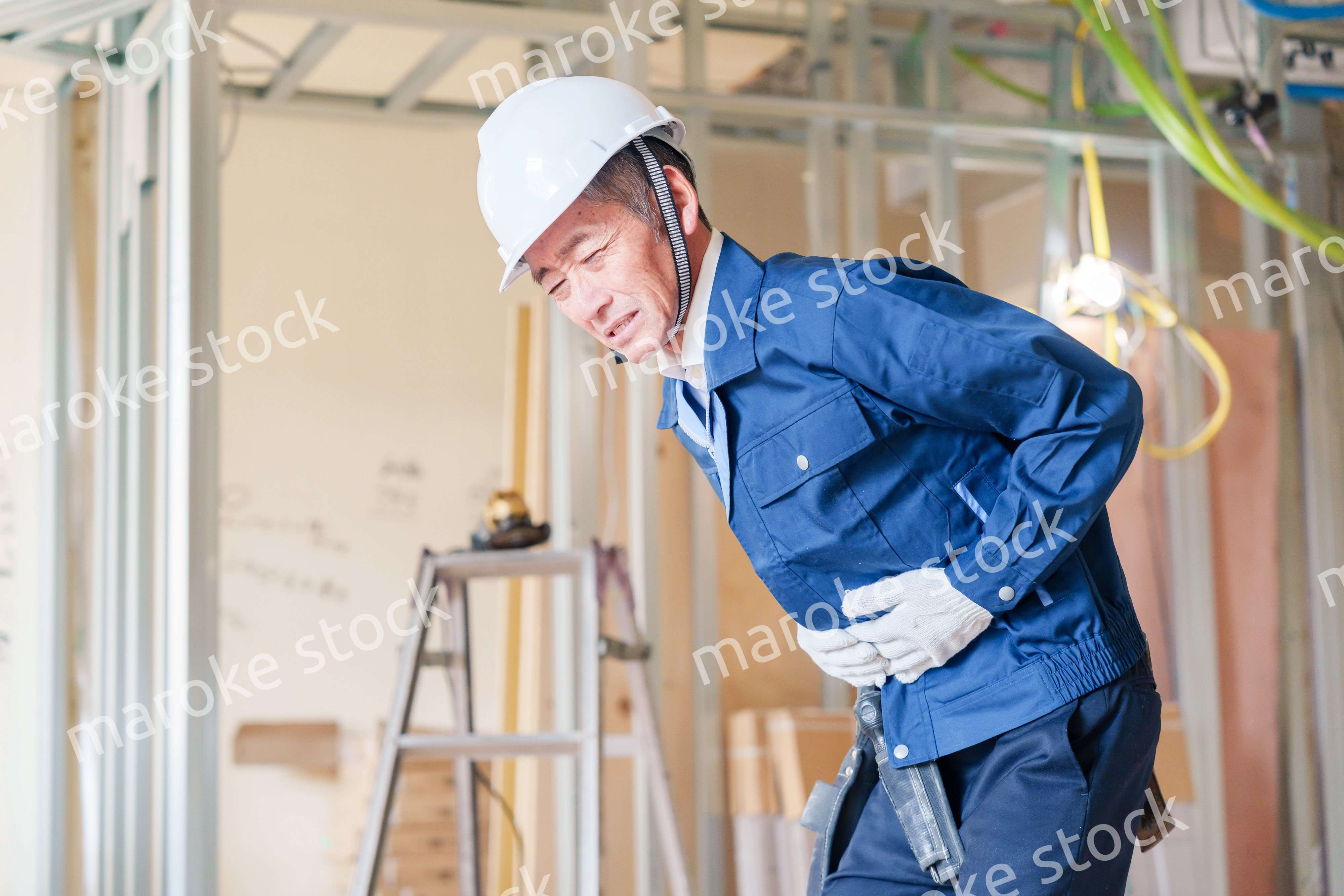 現場で腹痛に苦しむ男性の大工