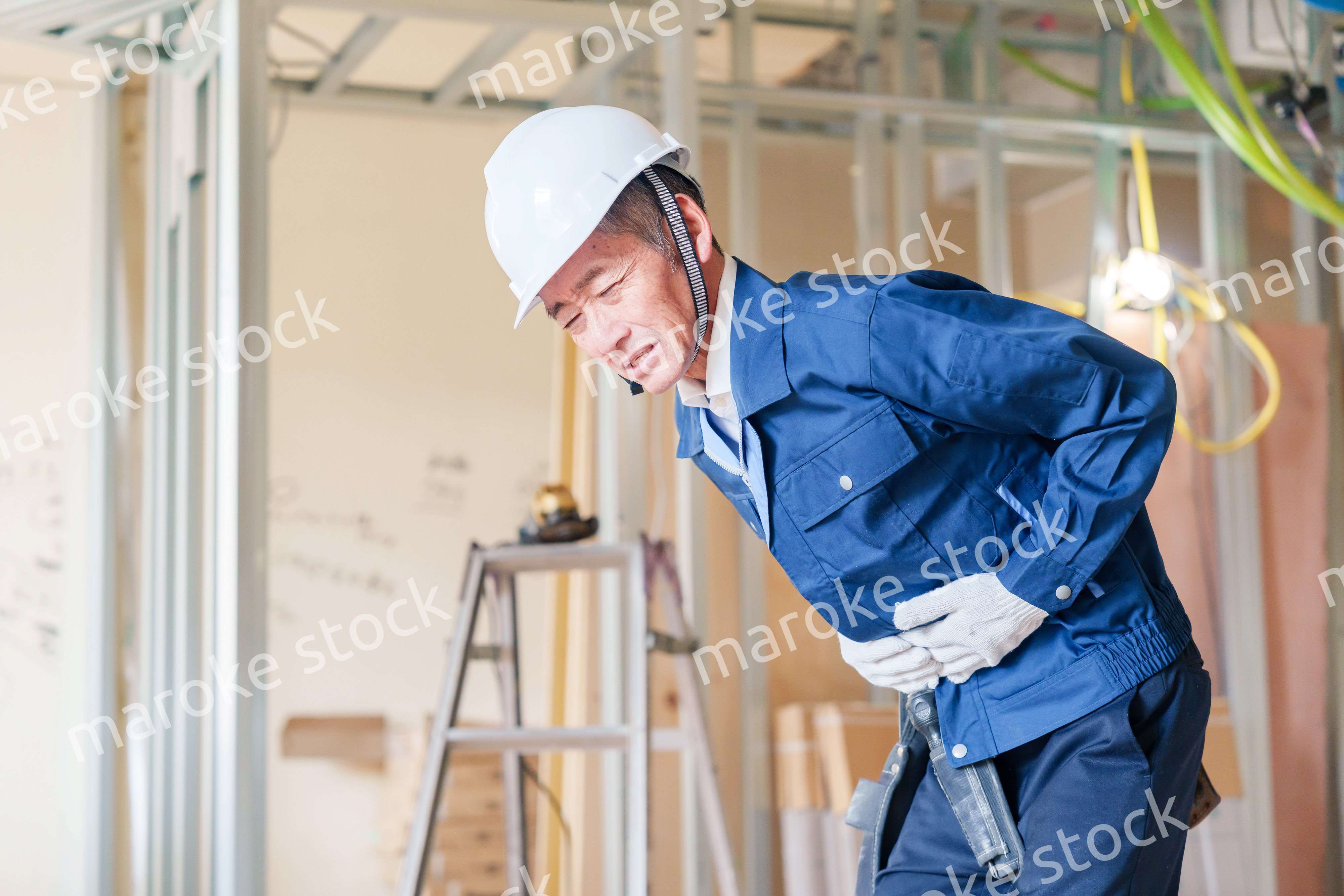 現場で腹痛に苦しむ男性の大工