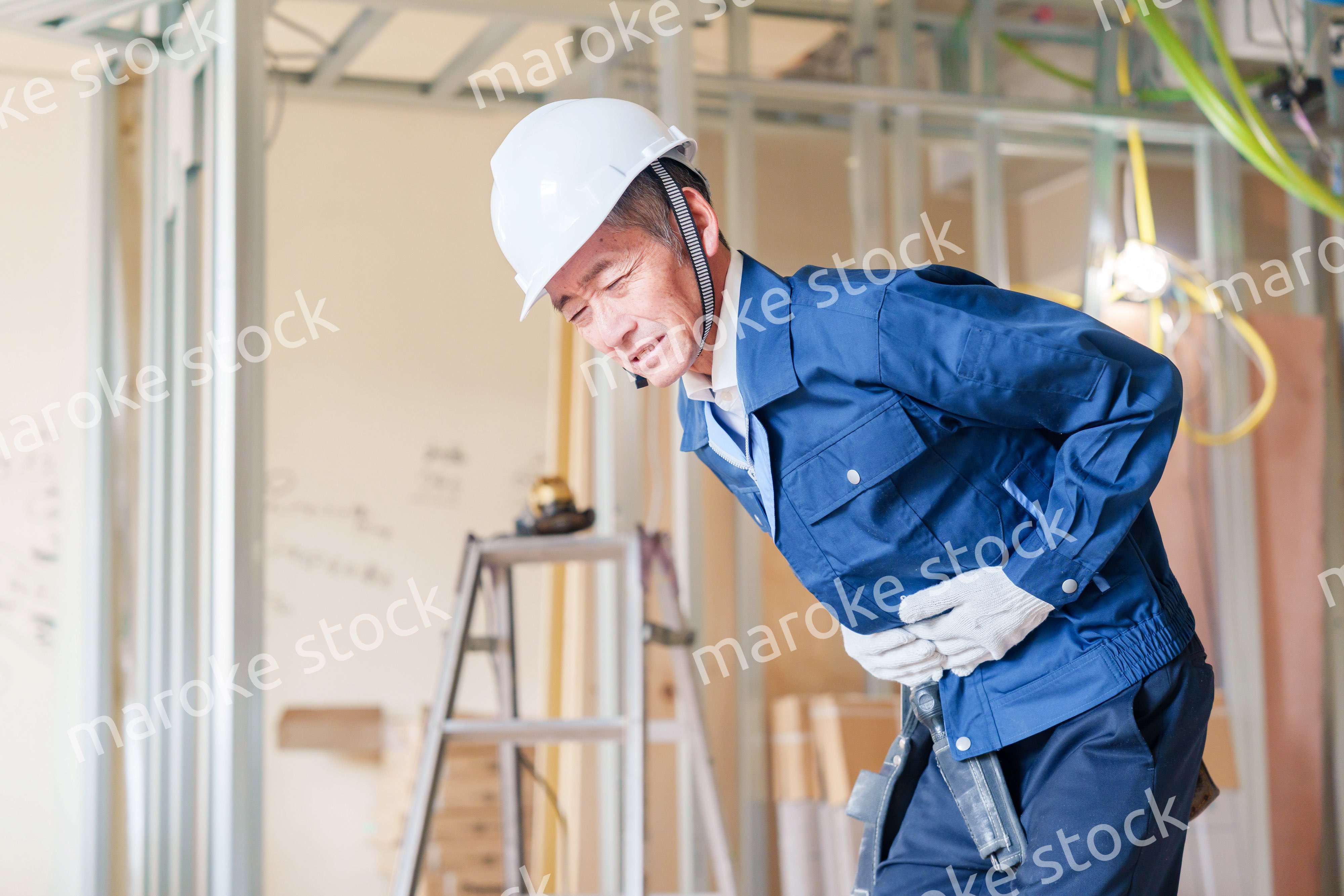 現場で腹痛に苦しむ男性の大工