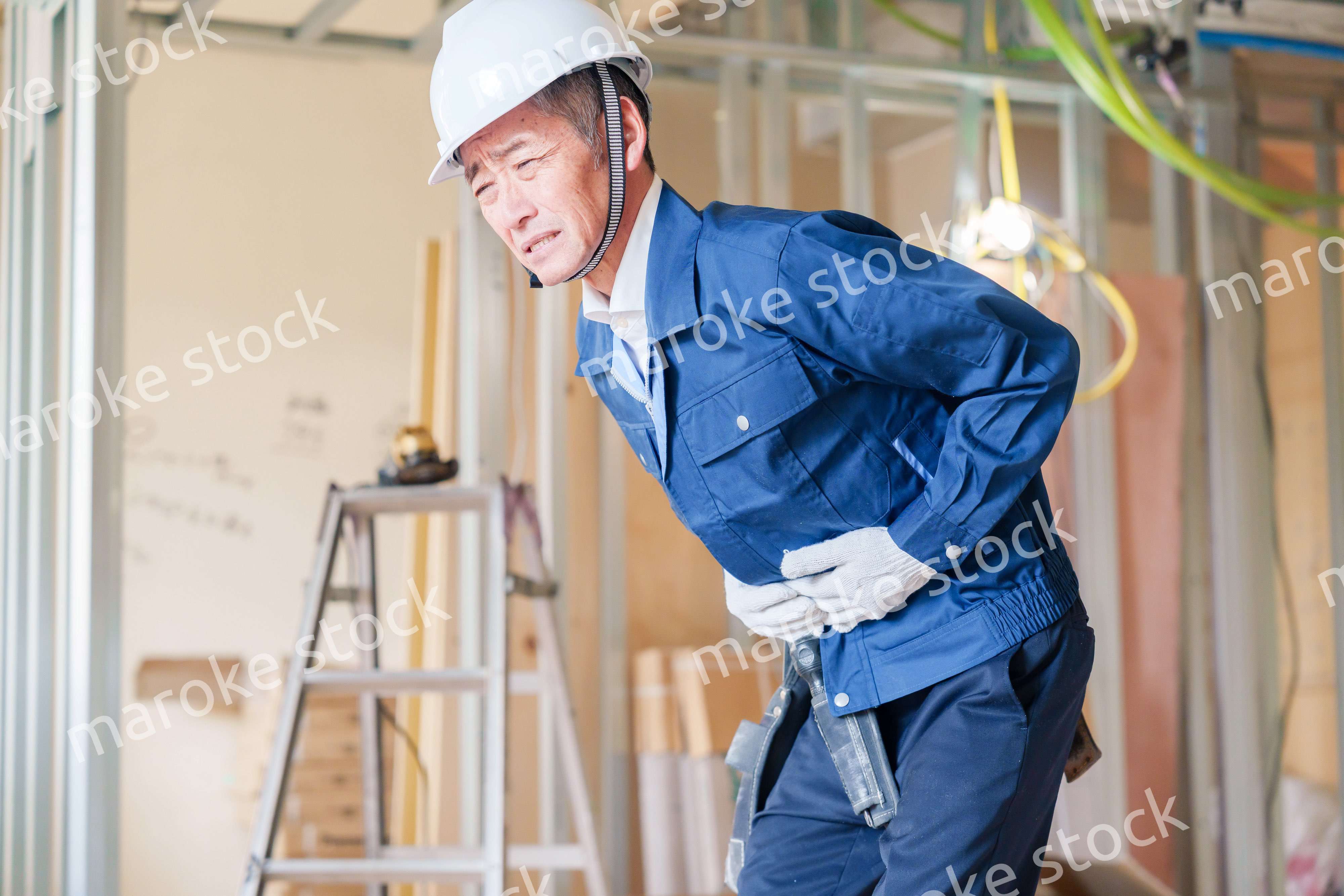 現場で腹痛に苦しむ男性の大工