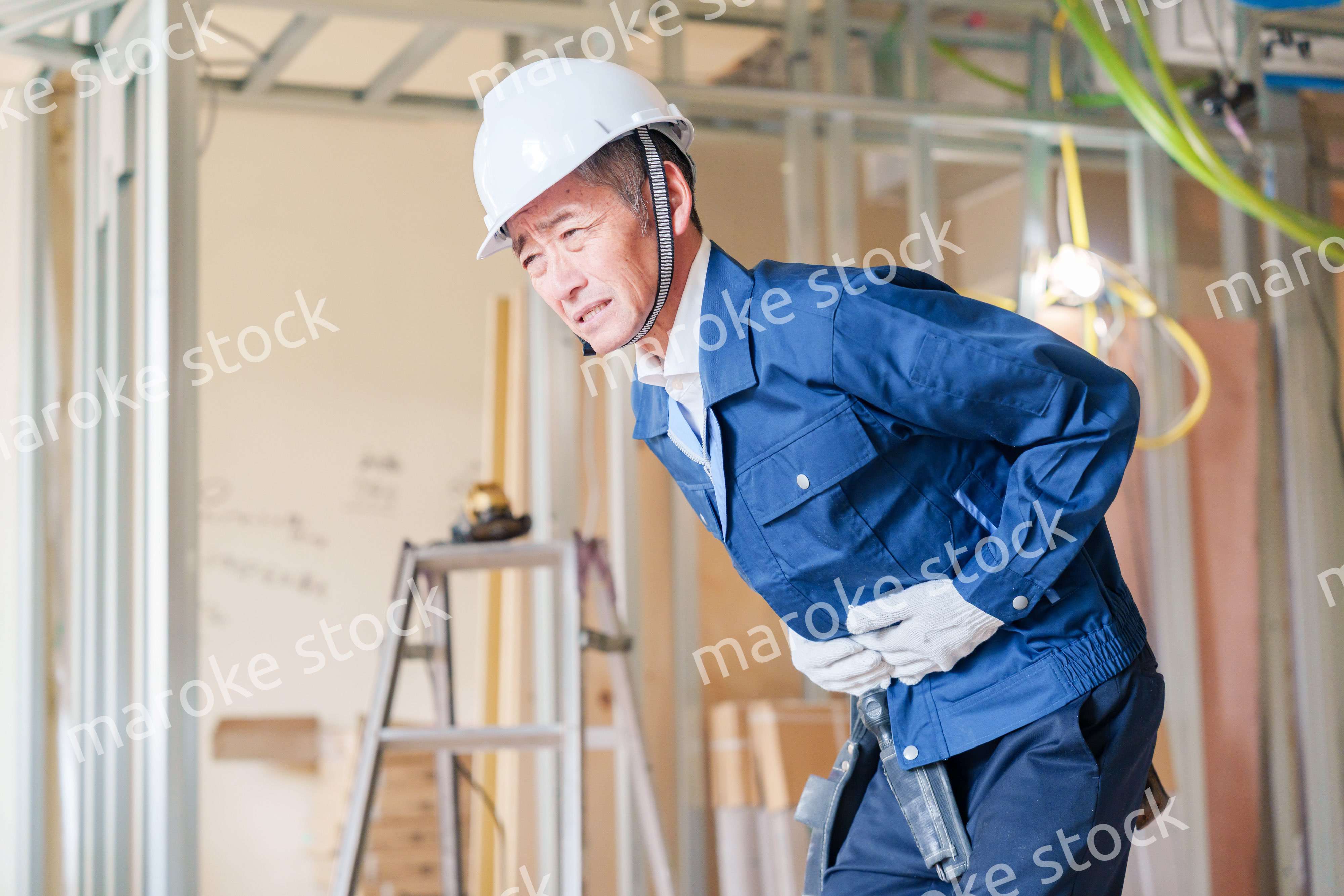 現場で腹痛に苦しむ男性の大工