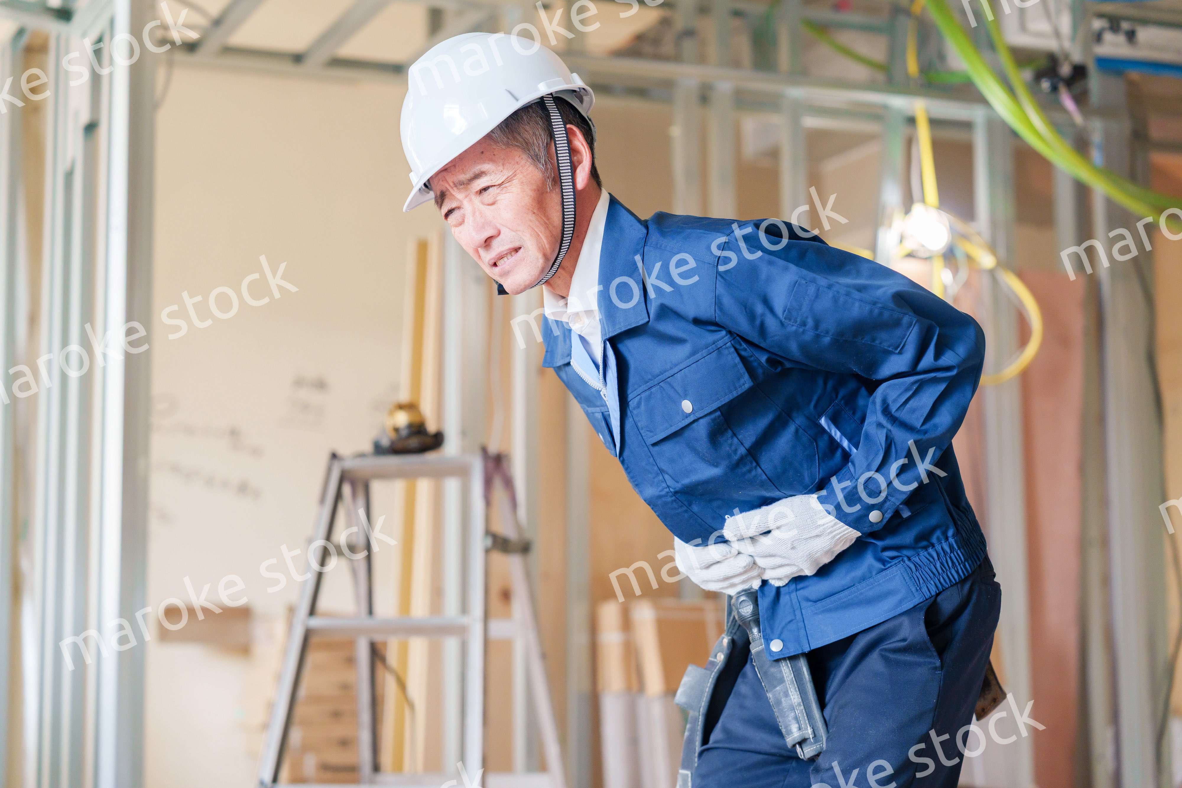 現場で腹痛に苦しむ男性の大工