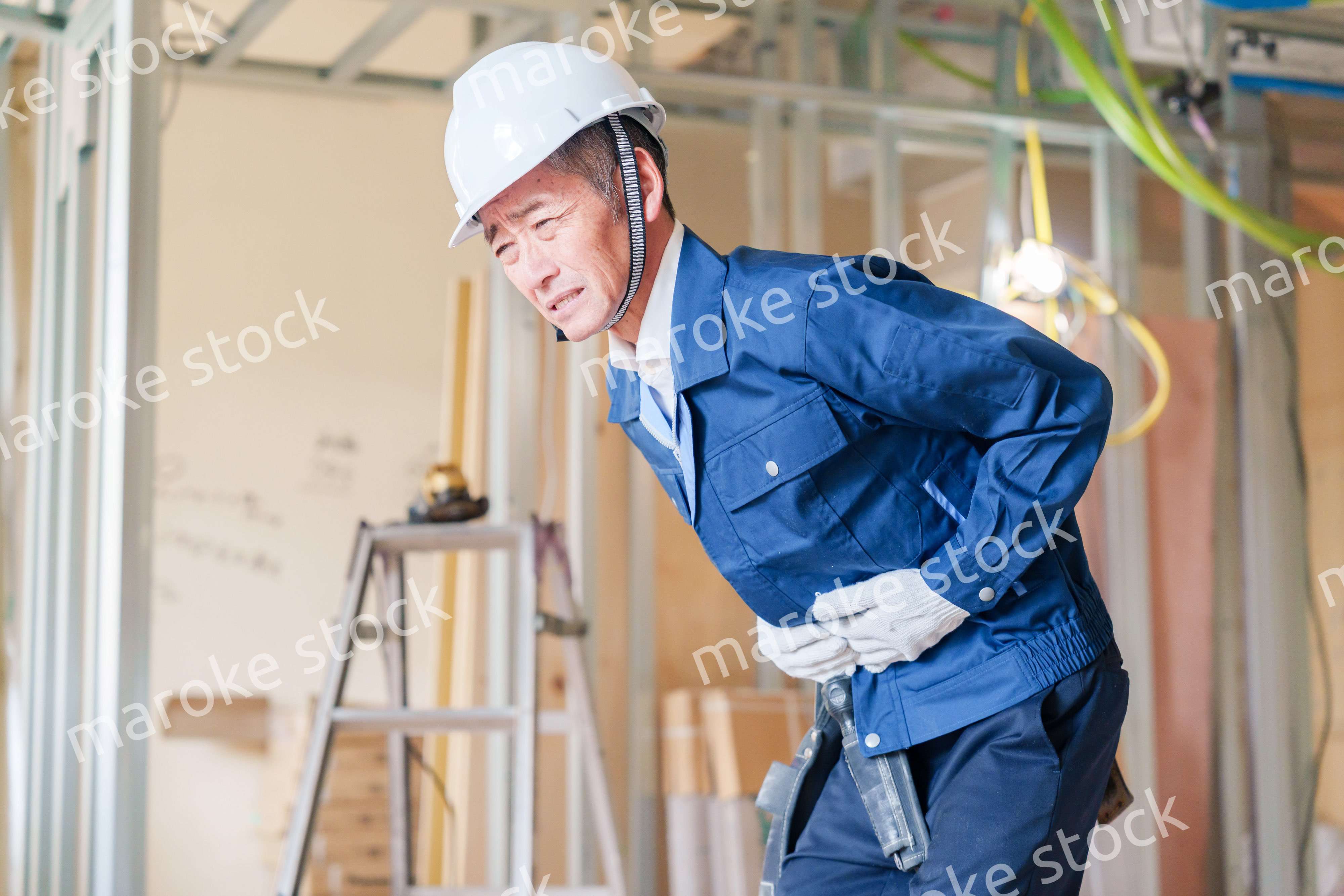 現場で腹痛に苦しむ男性の大工