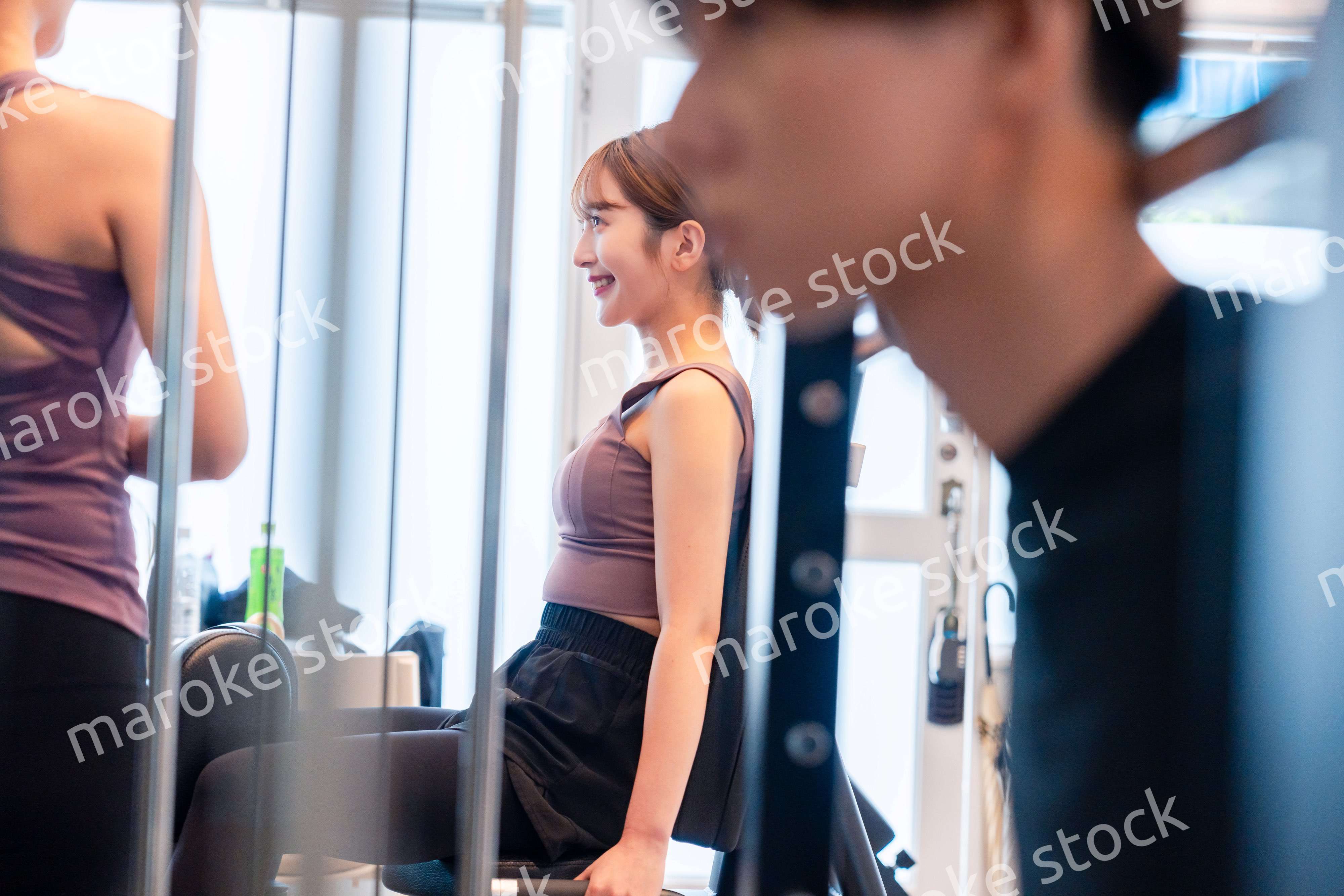 ジムのマシーンでトレーニングをする人