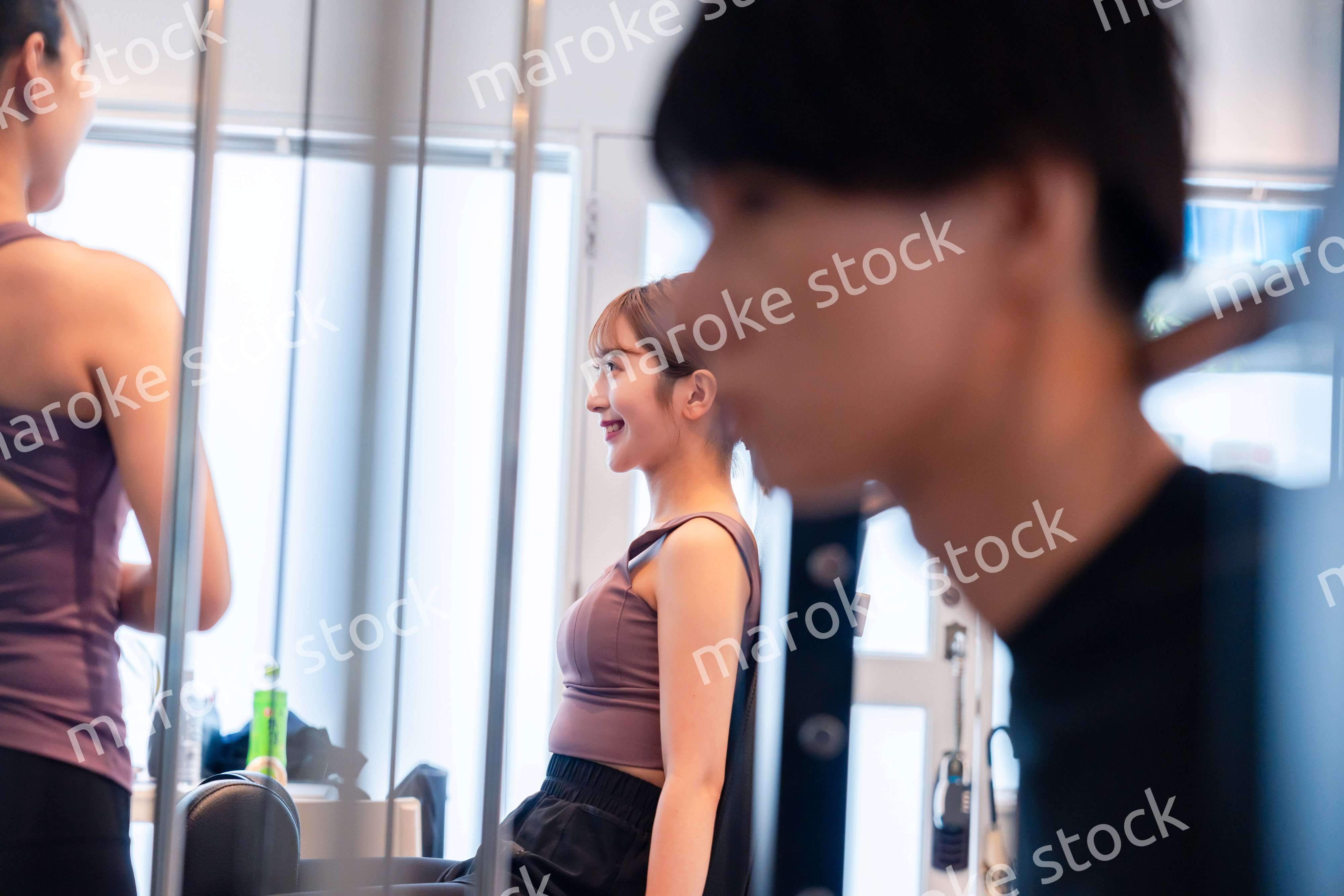 ジムのマシーンでトレーニングをする人