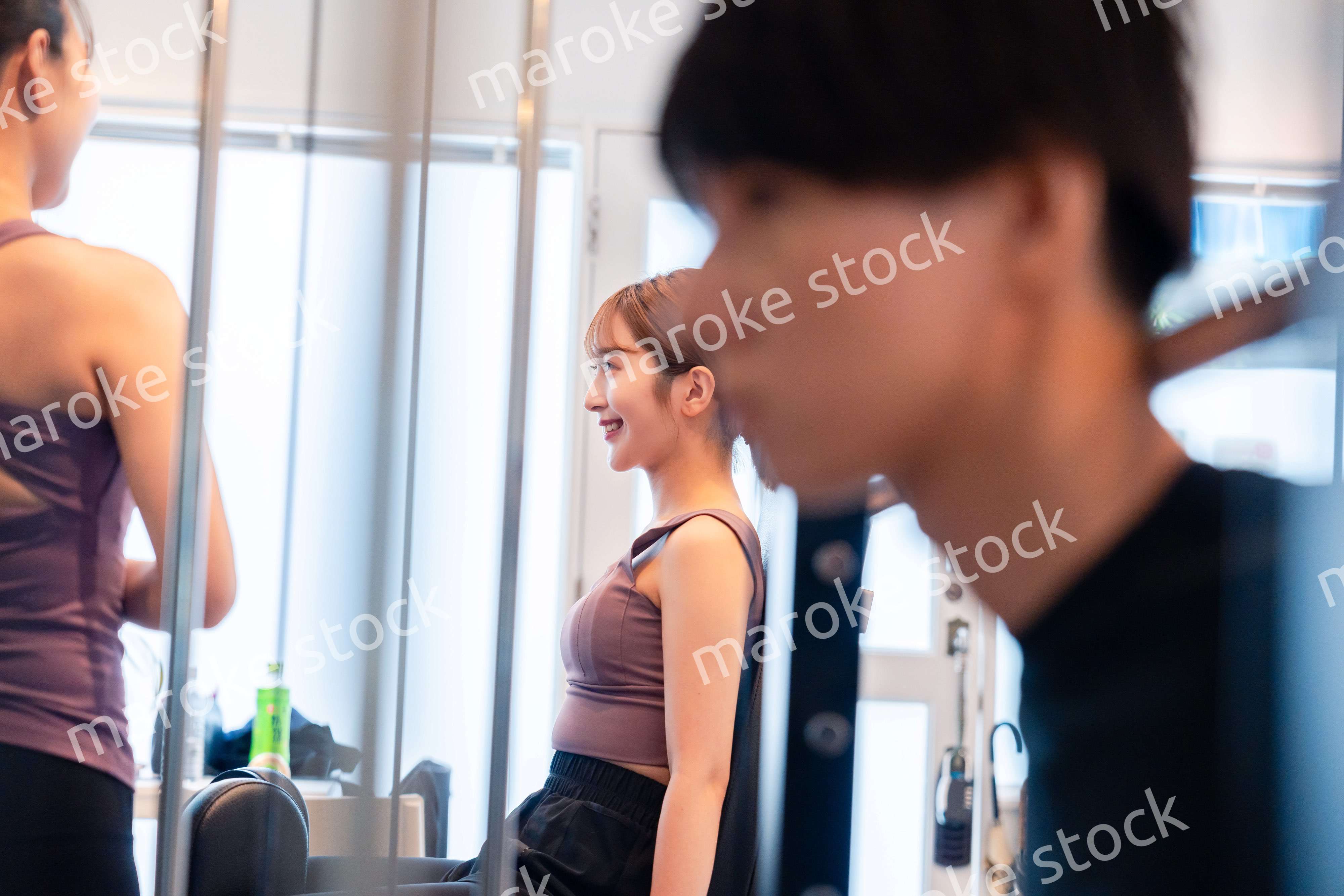 ジムのマシーンでトレーニングをする人