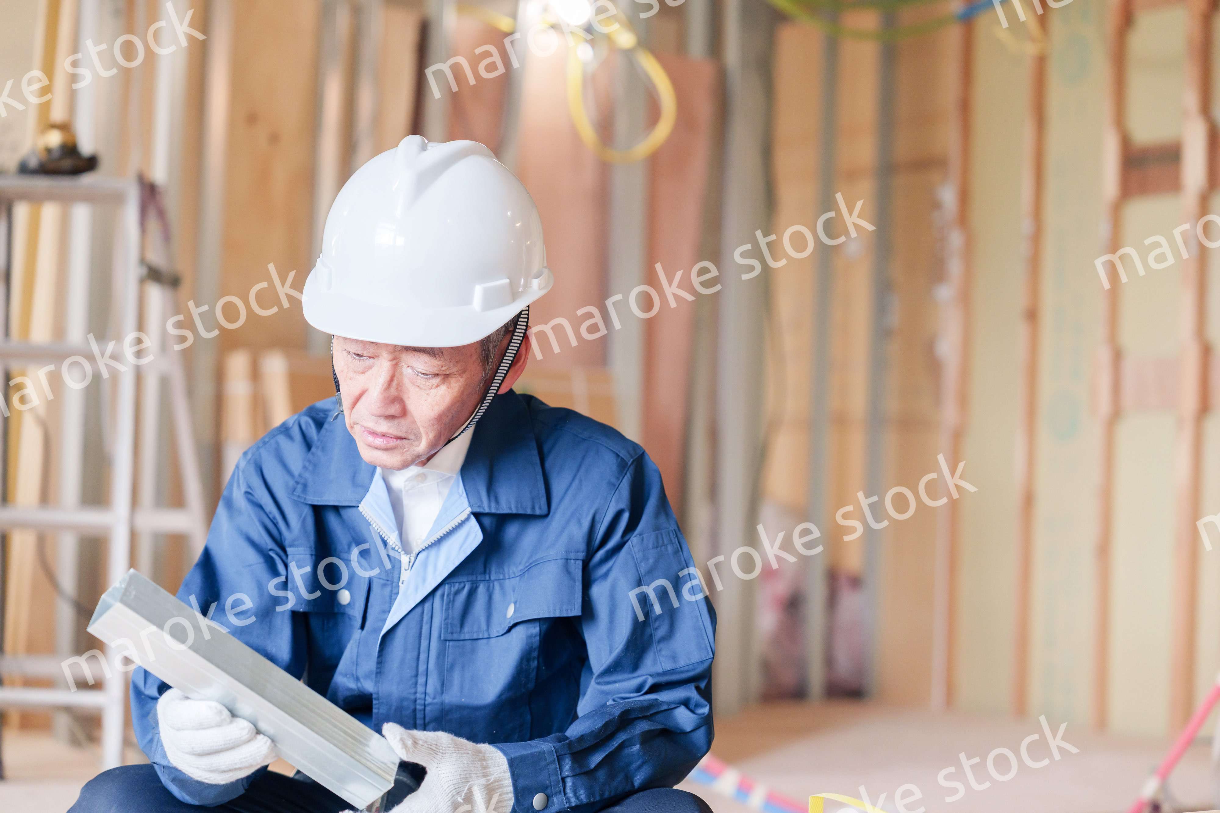 建設現場で軽量鉄骨の確認をする男性の職人