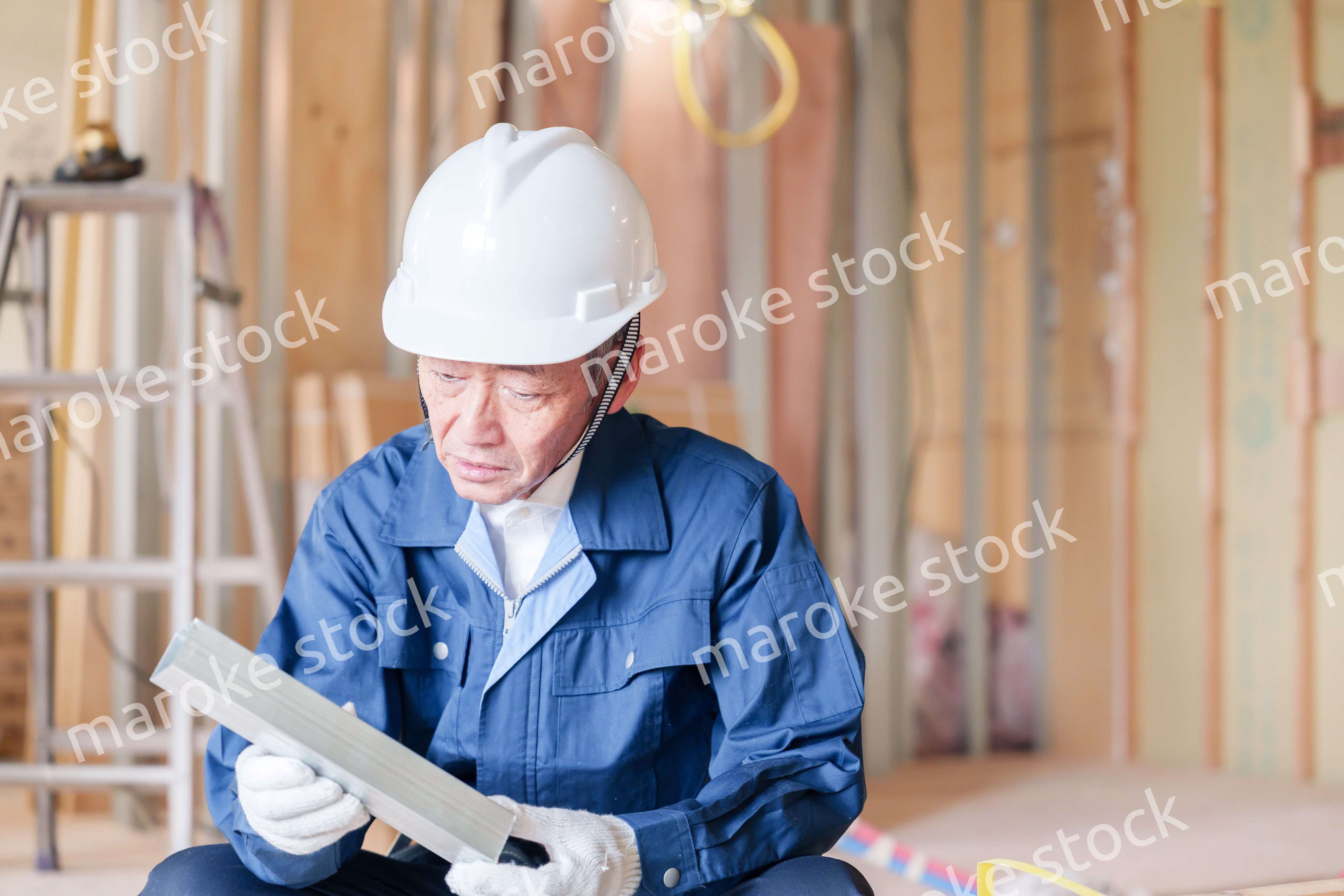 建設現場で軽量鉄骨の確認をする男性の職人