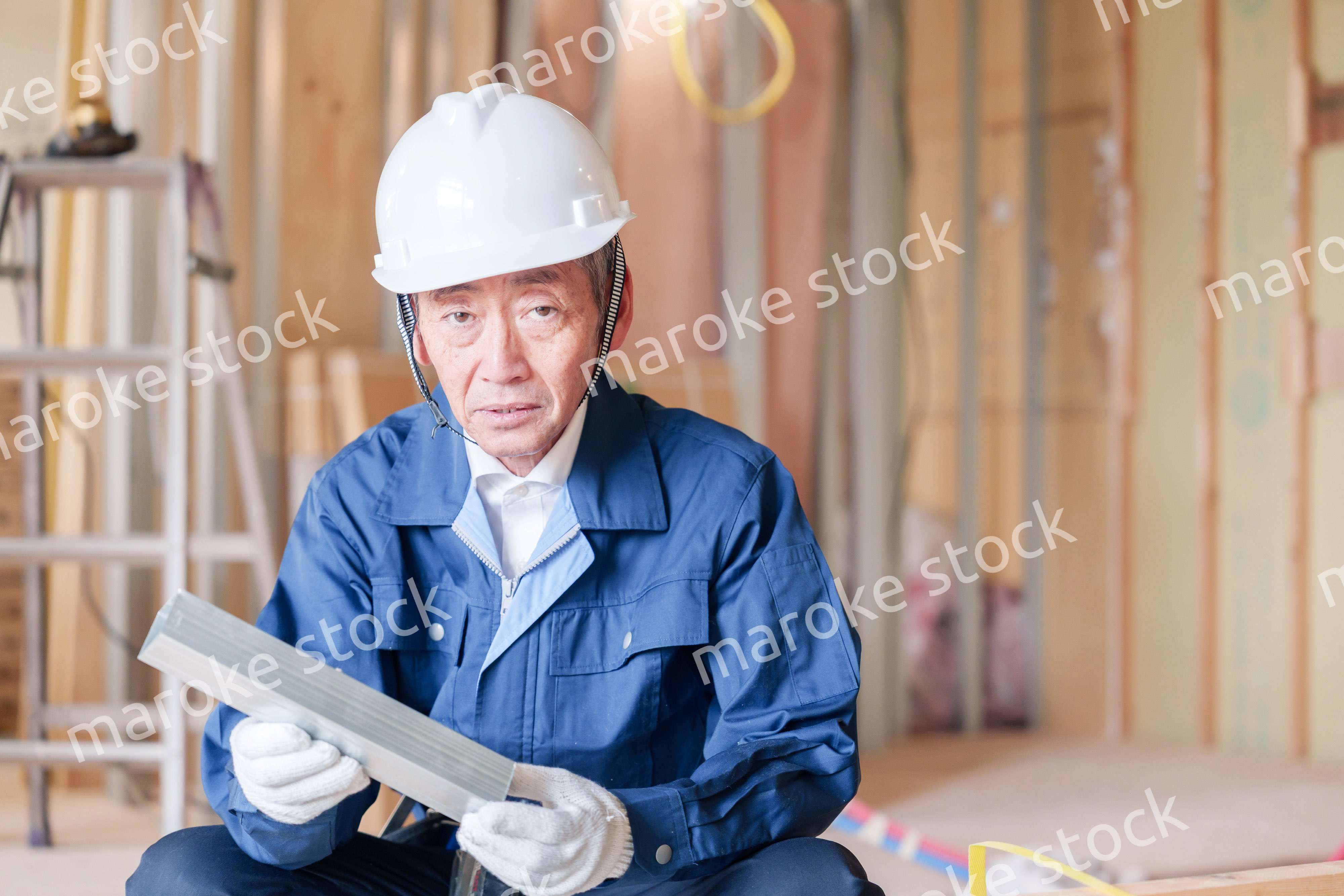 建設現場で軽量鉄骨の確認をする男性の職人