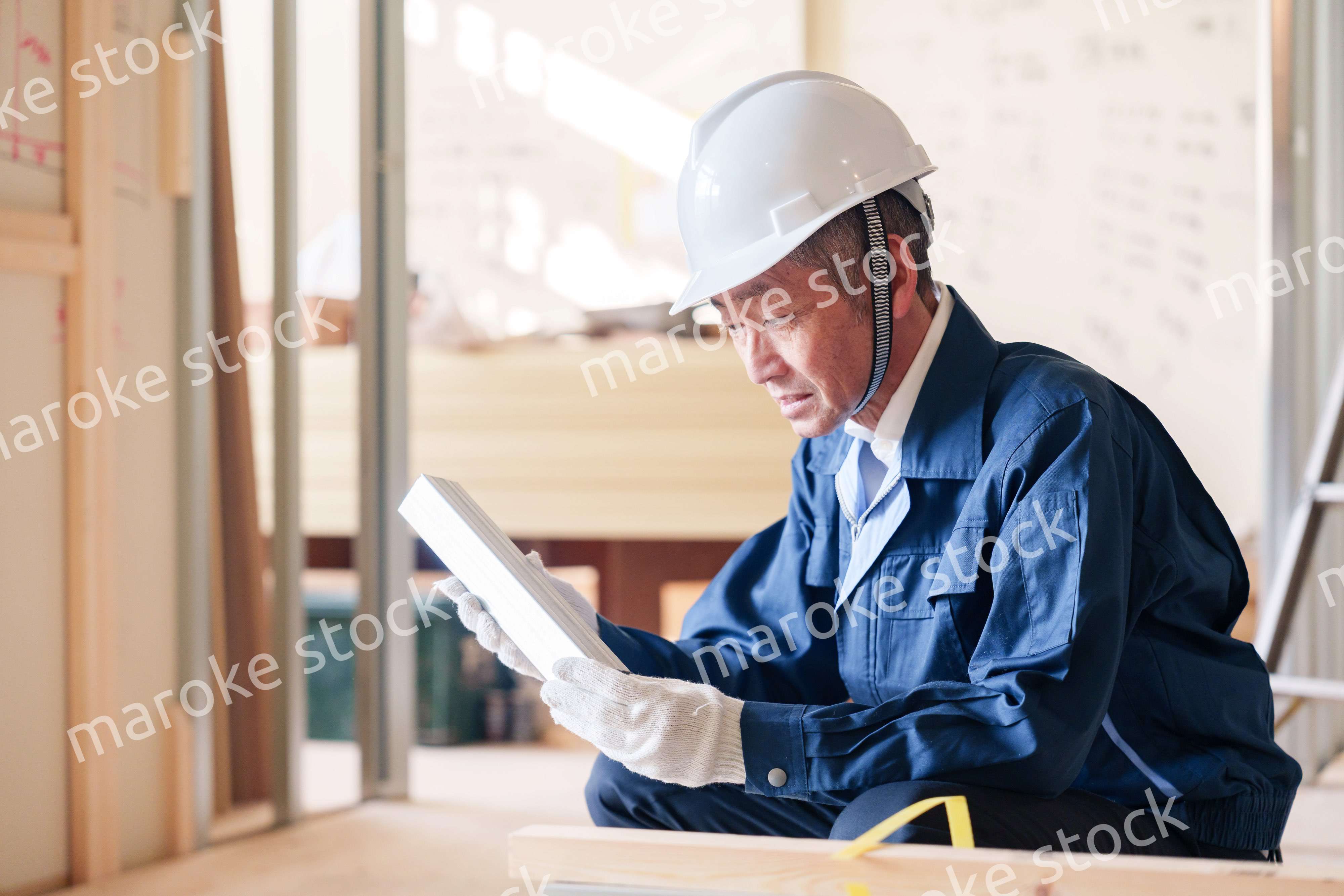 建設現場で軽量鉄骨の確認をする男性の職人