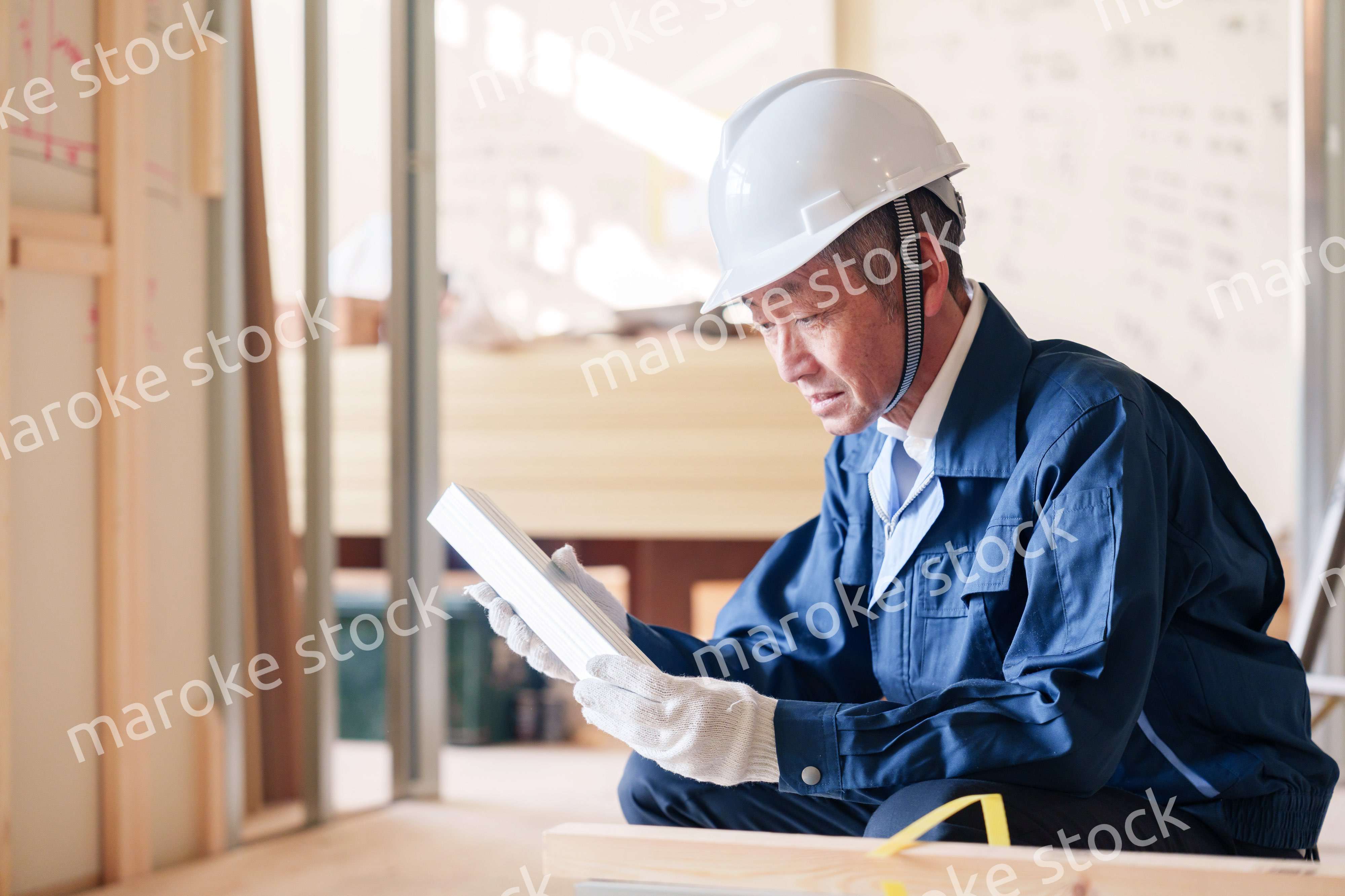 建設現場で軽量鉄骨の確認をする男性の職人