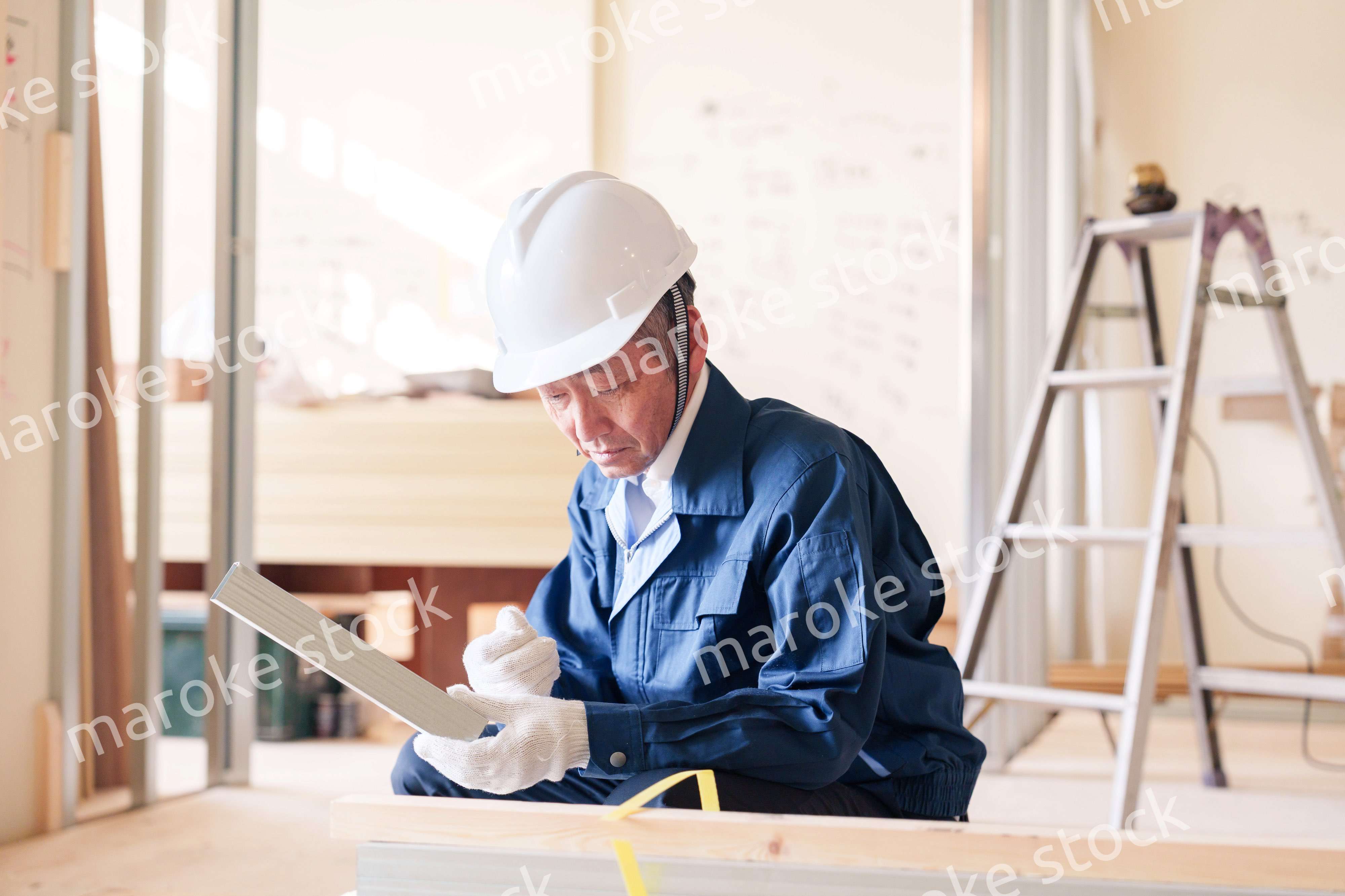 建設現場で軽量鉄骨の確認をする男性の職人