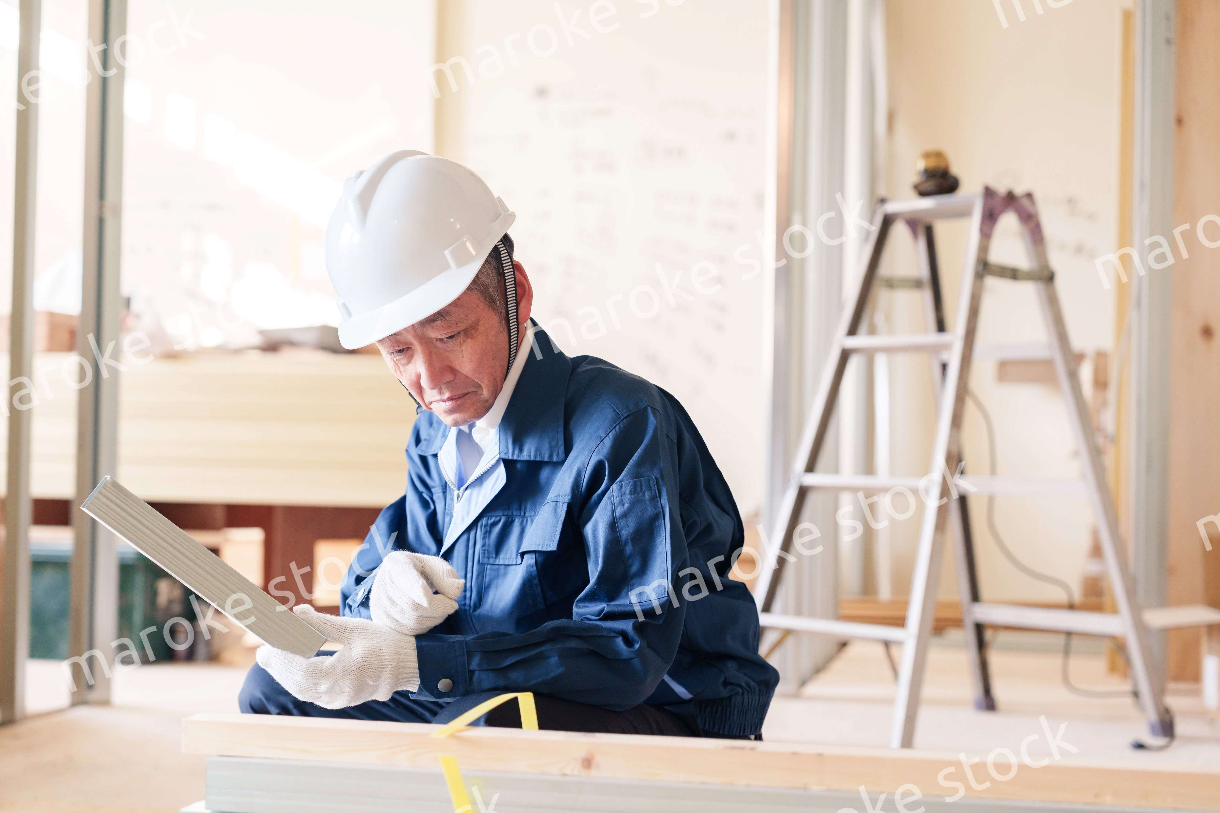 建設現場で軽量鉄骨の確認をする男性の職人