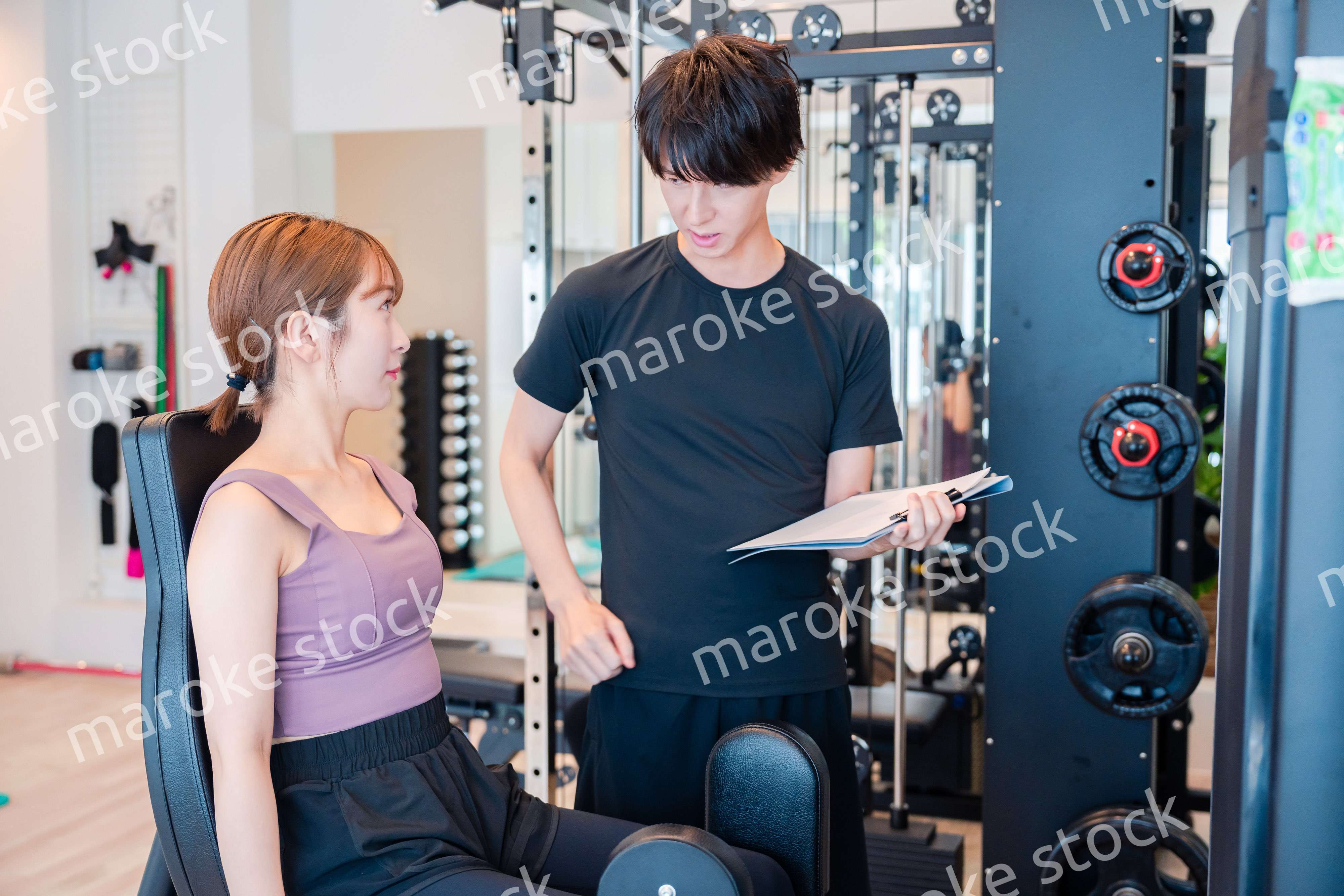 パーソナルジムに通う女性とトレーナー