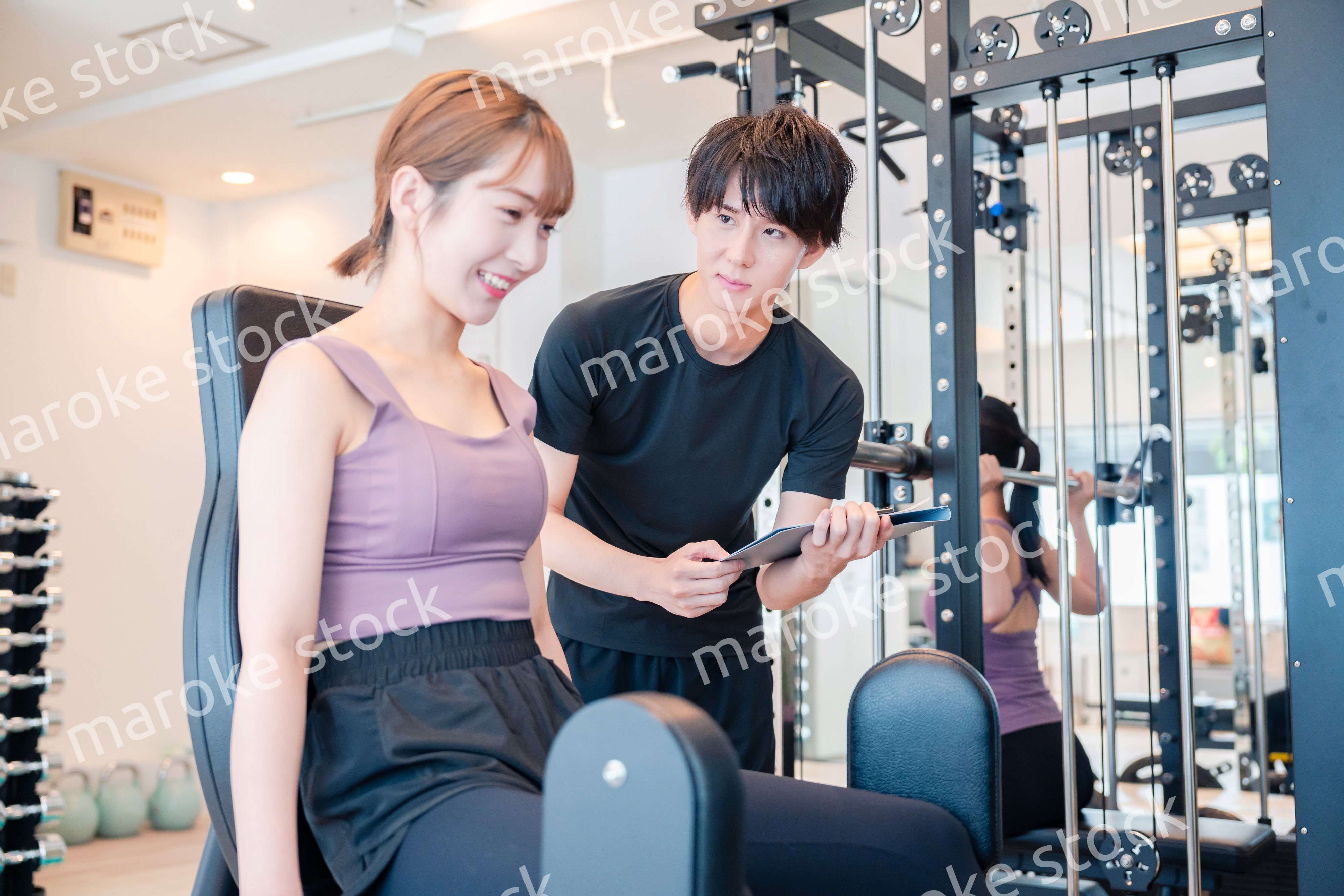 ジムのマシーンでトレーニングをする人