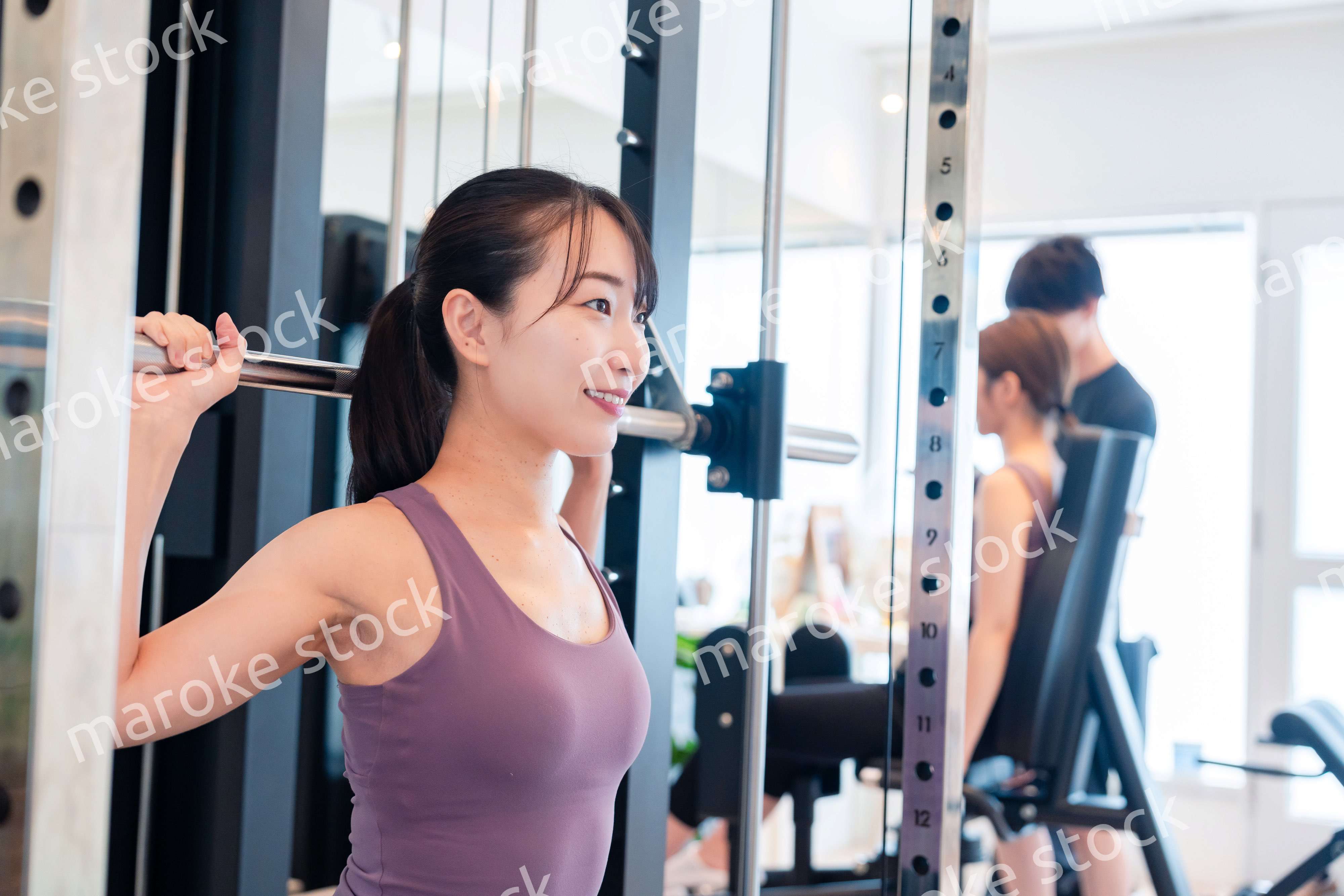 ジムのマシーンでトレーニングをする人