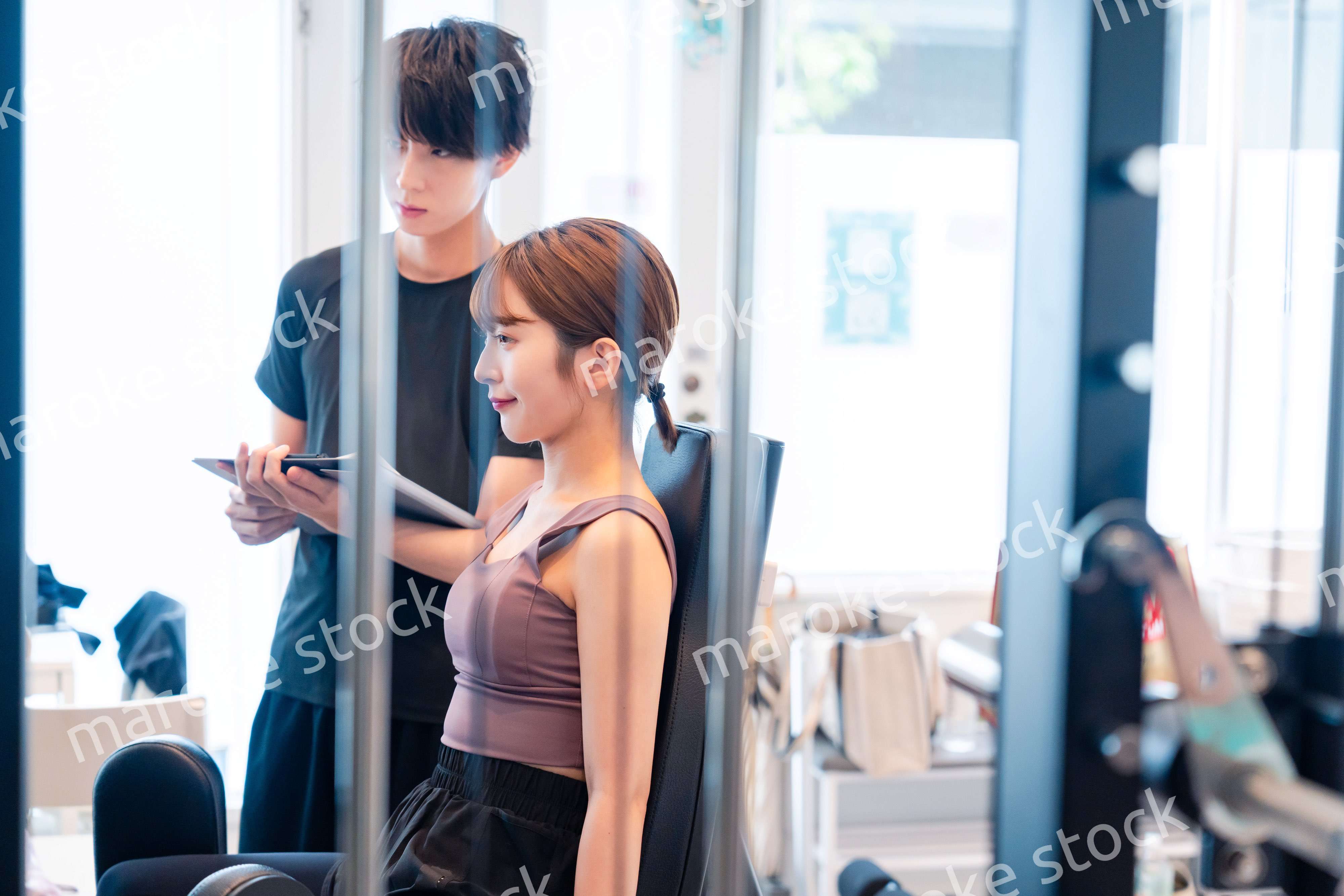 パーソナルジムに通う女性とトレーナー