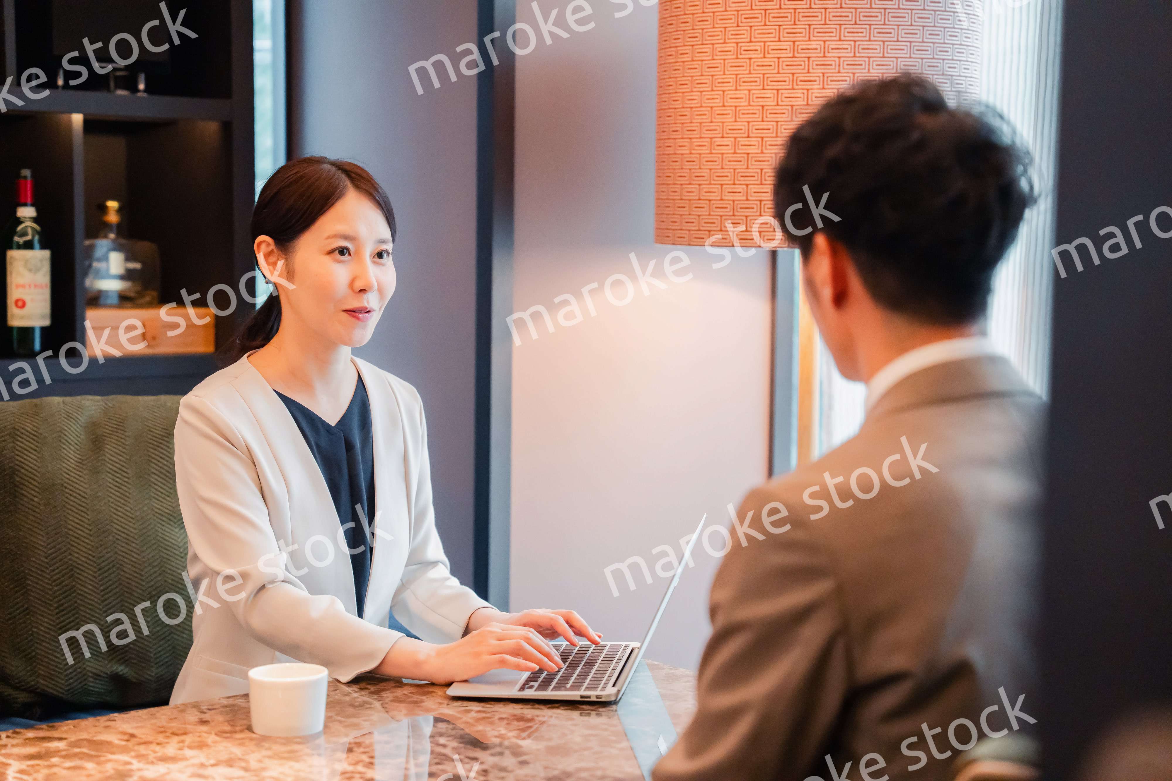 ホテルのラウンジでビジネスミーティングをする人々