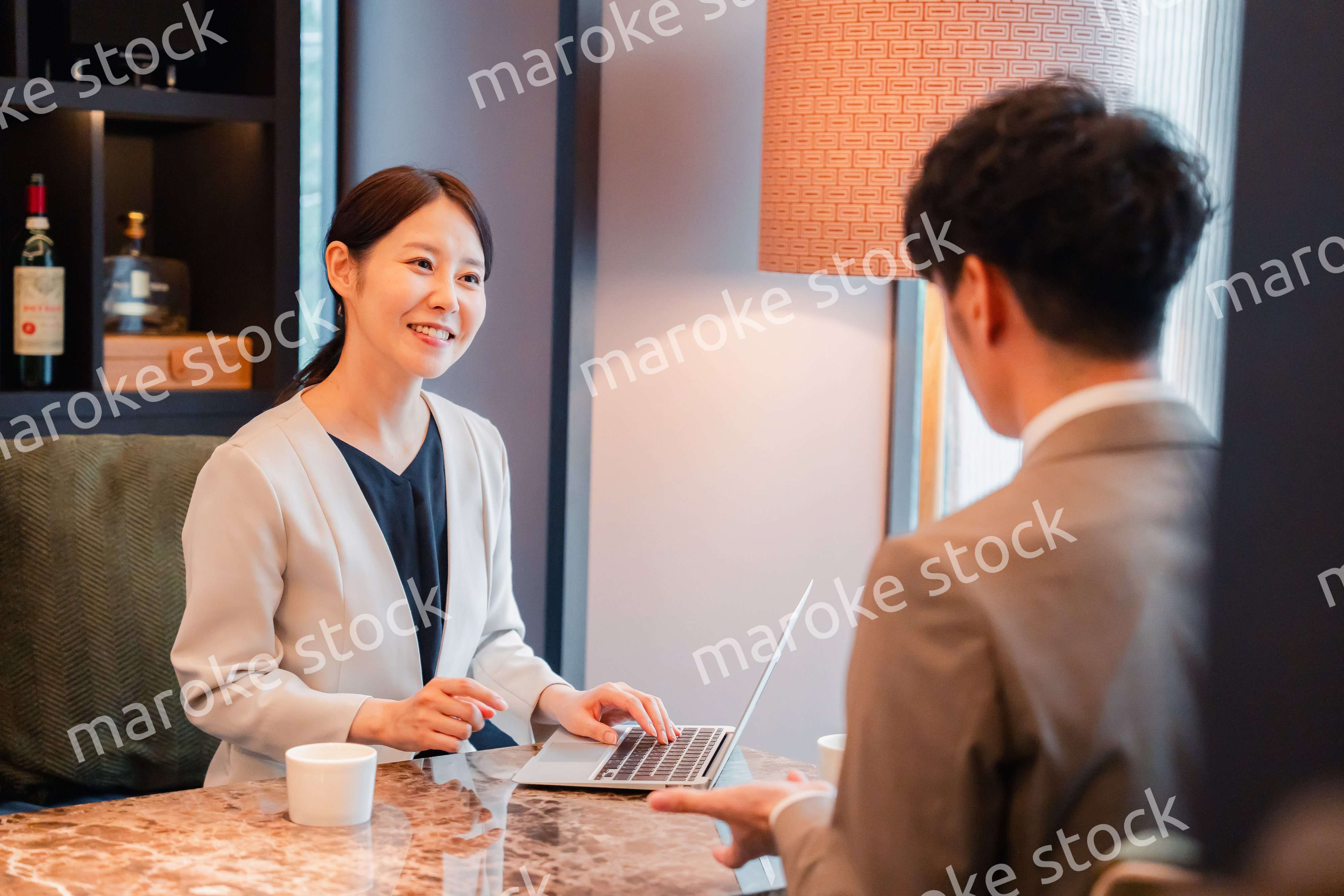 ホテルのラウンジでビジネスミーティングをする人々