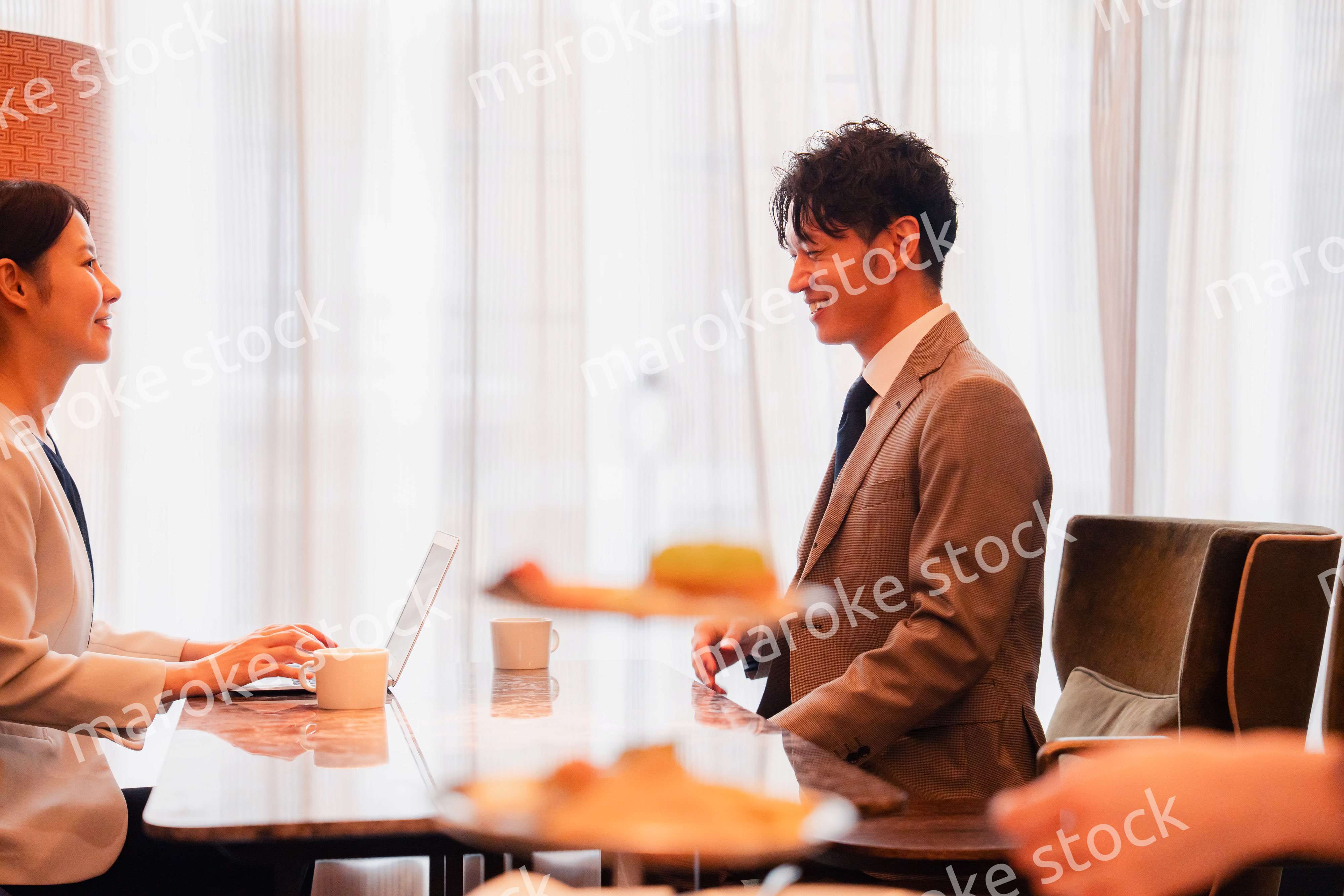 ホテルのラウンジでビジネスミーティングをする人々