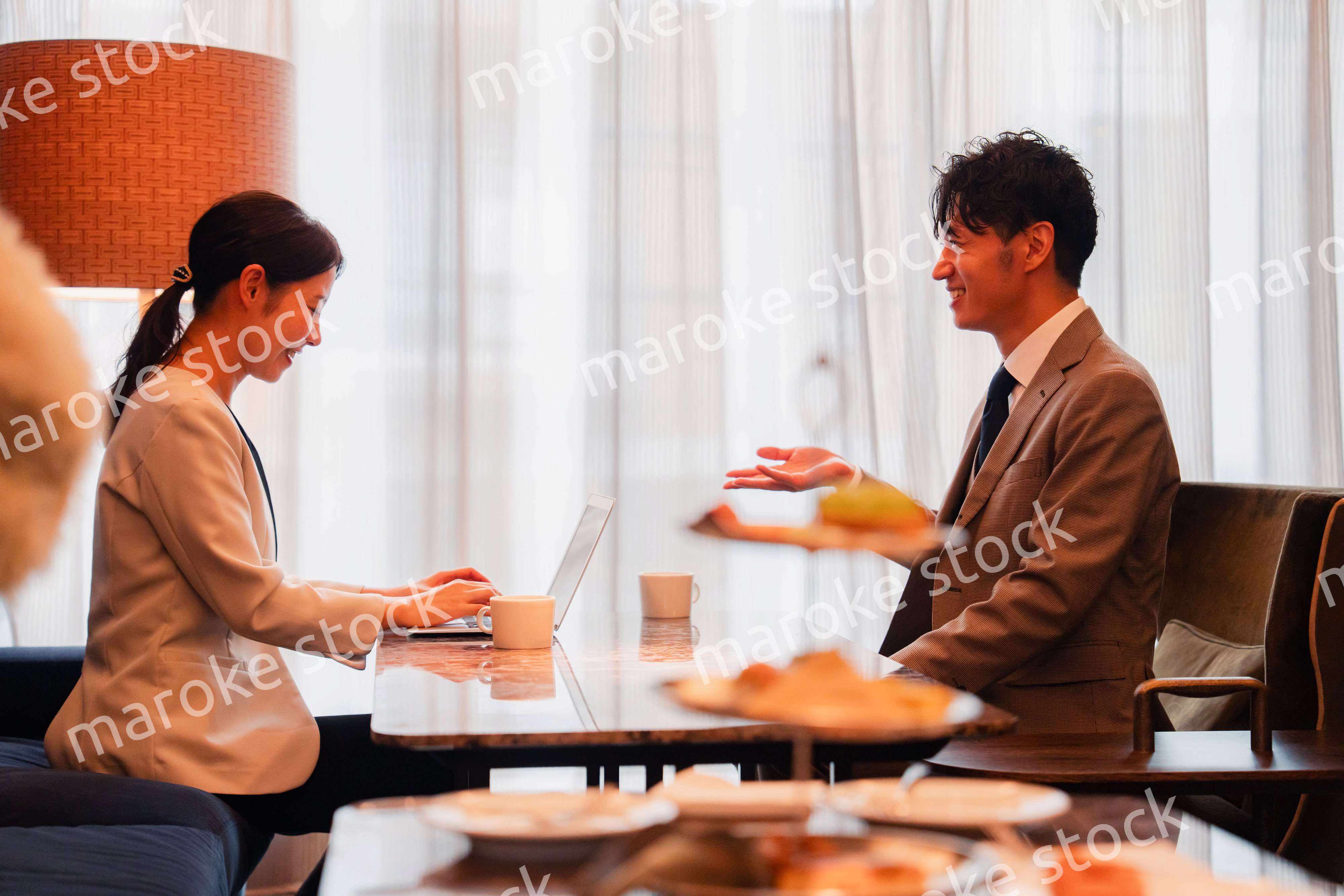 ホテルのラウンジでビジネスミーティングをする人々