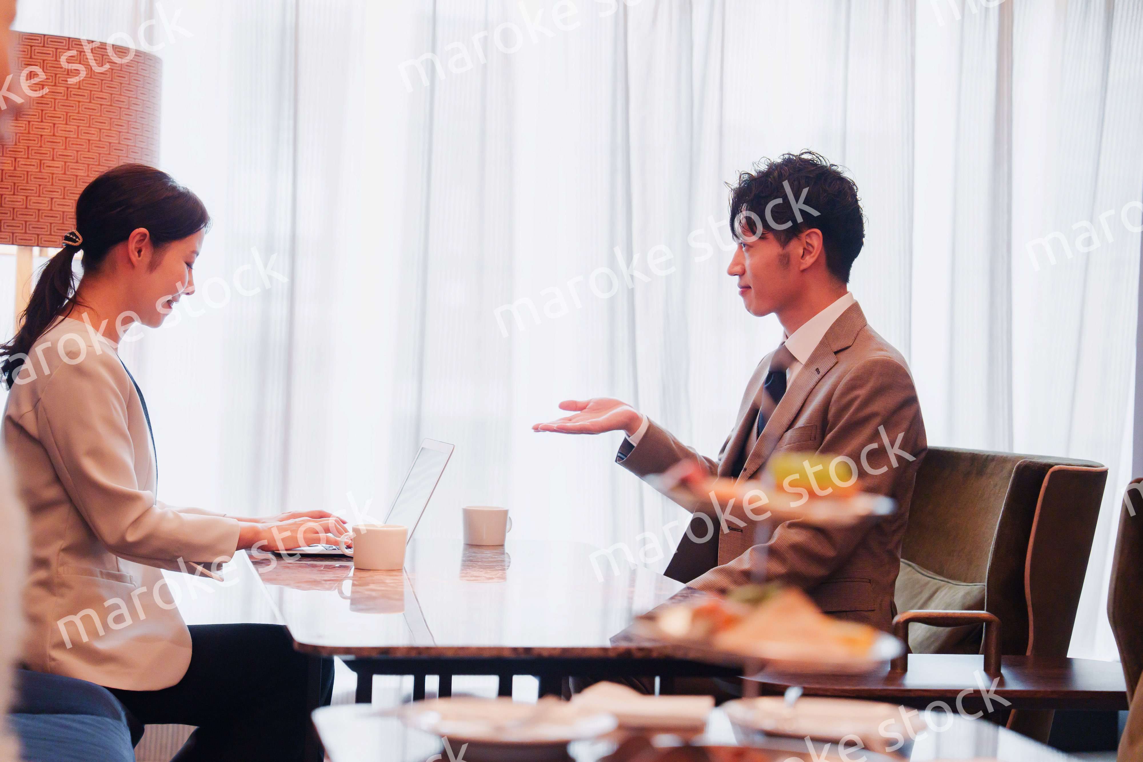 ラウンジでビジネスミーティングをする男女のビジネスパーソン