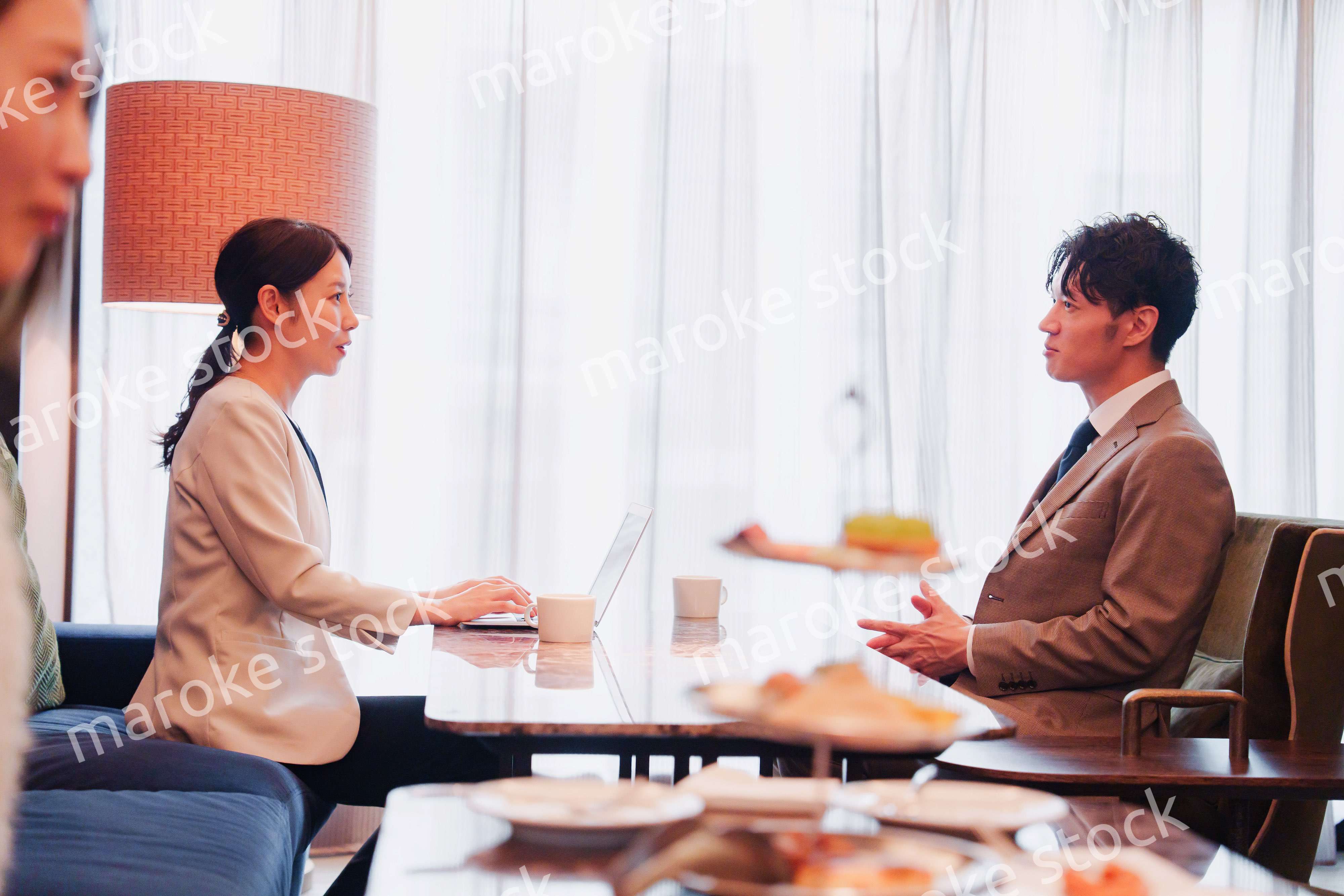 ラウンジでビジネスミーティングをする男女のビジネスパーソン