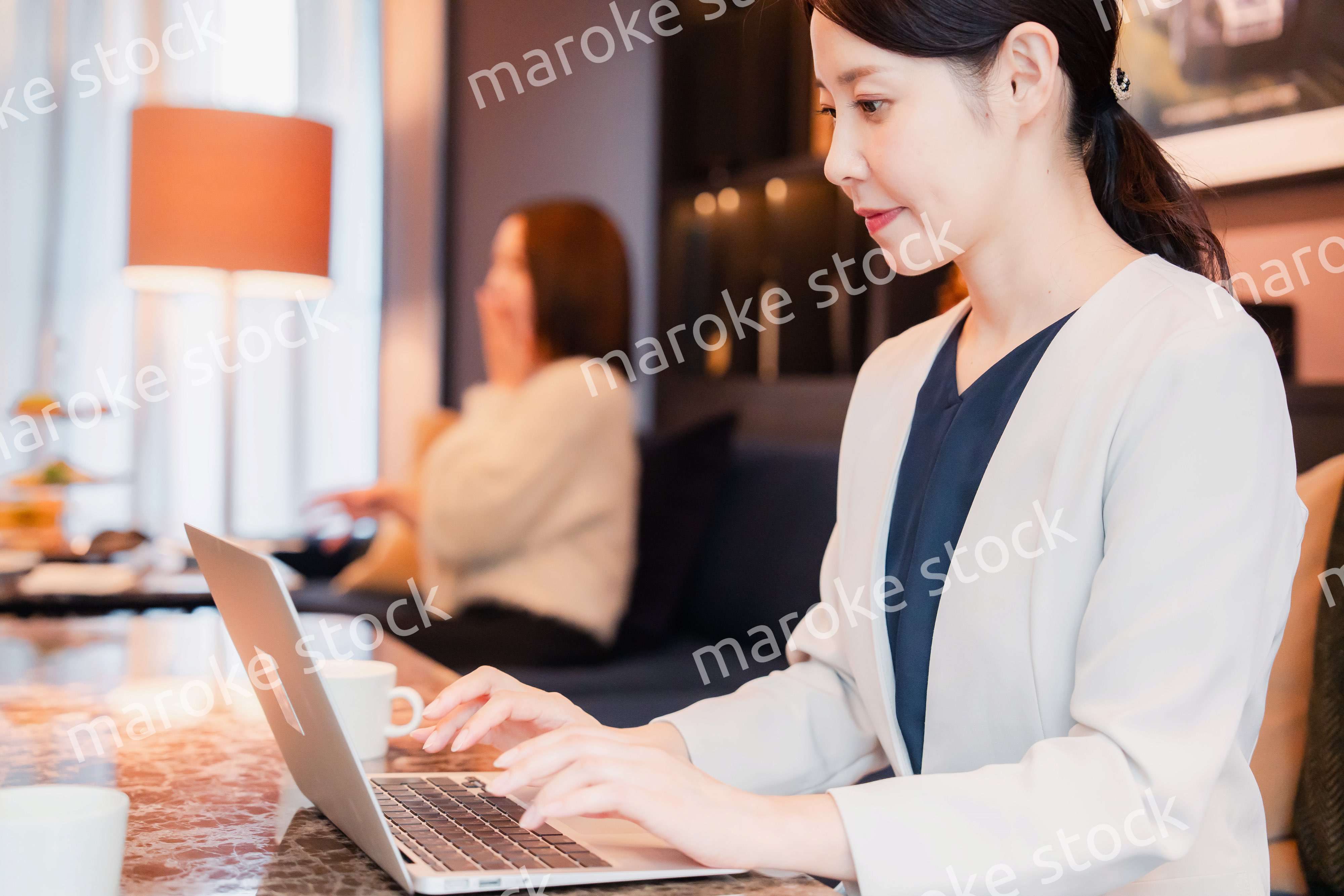 ホテルのラウンジで仕事をする女性のビジネスパーソン