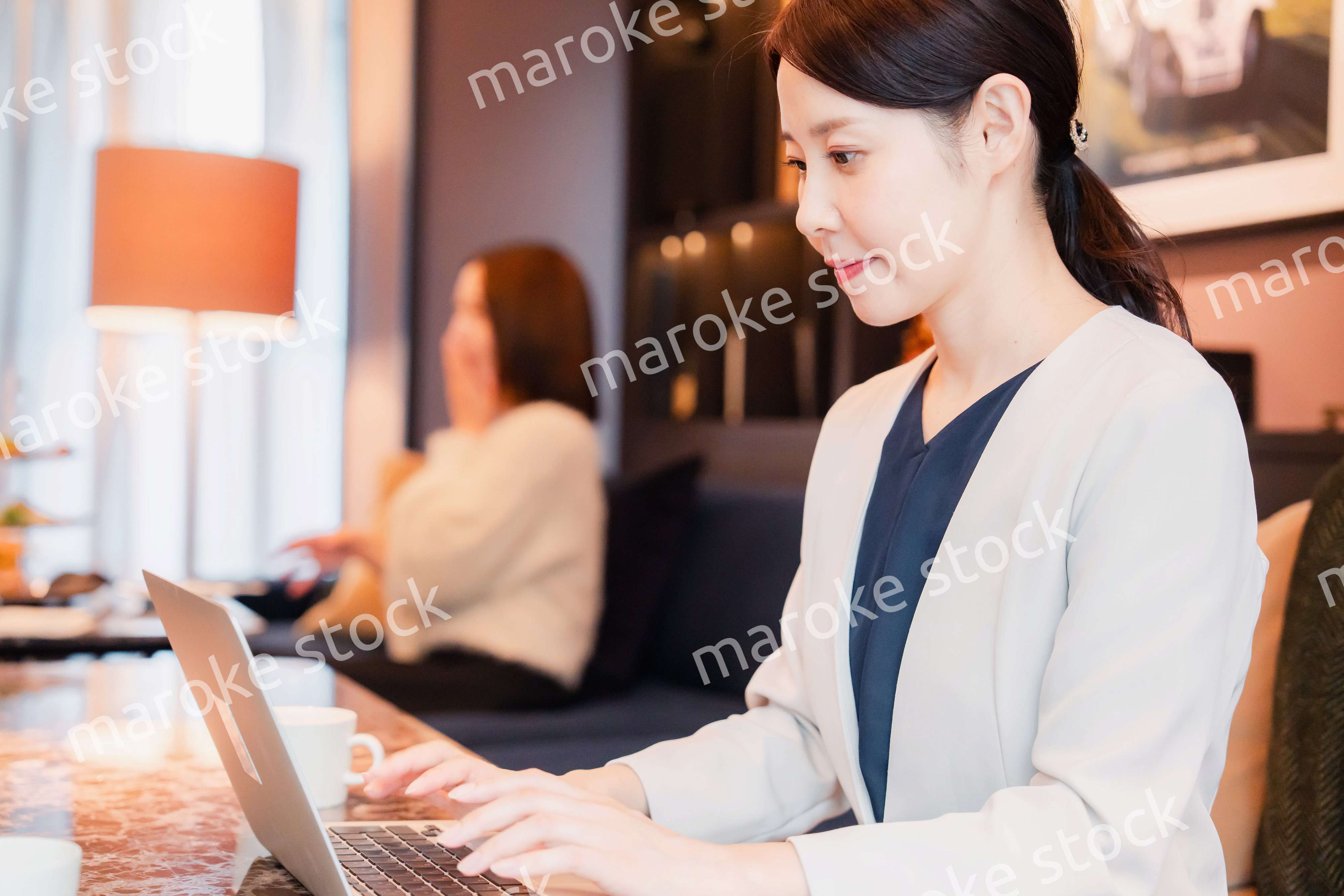 ホテルのラウンジで仕事をする女性のビジネスパーソン