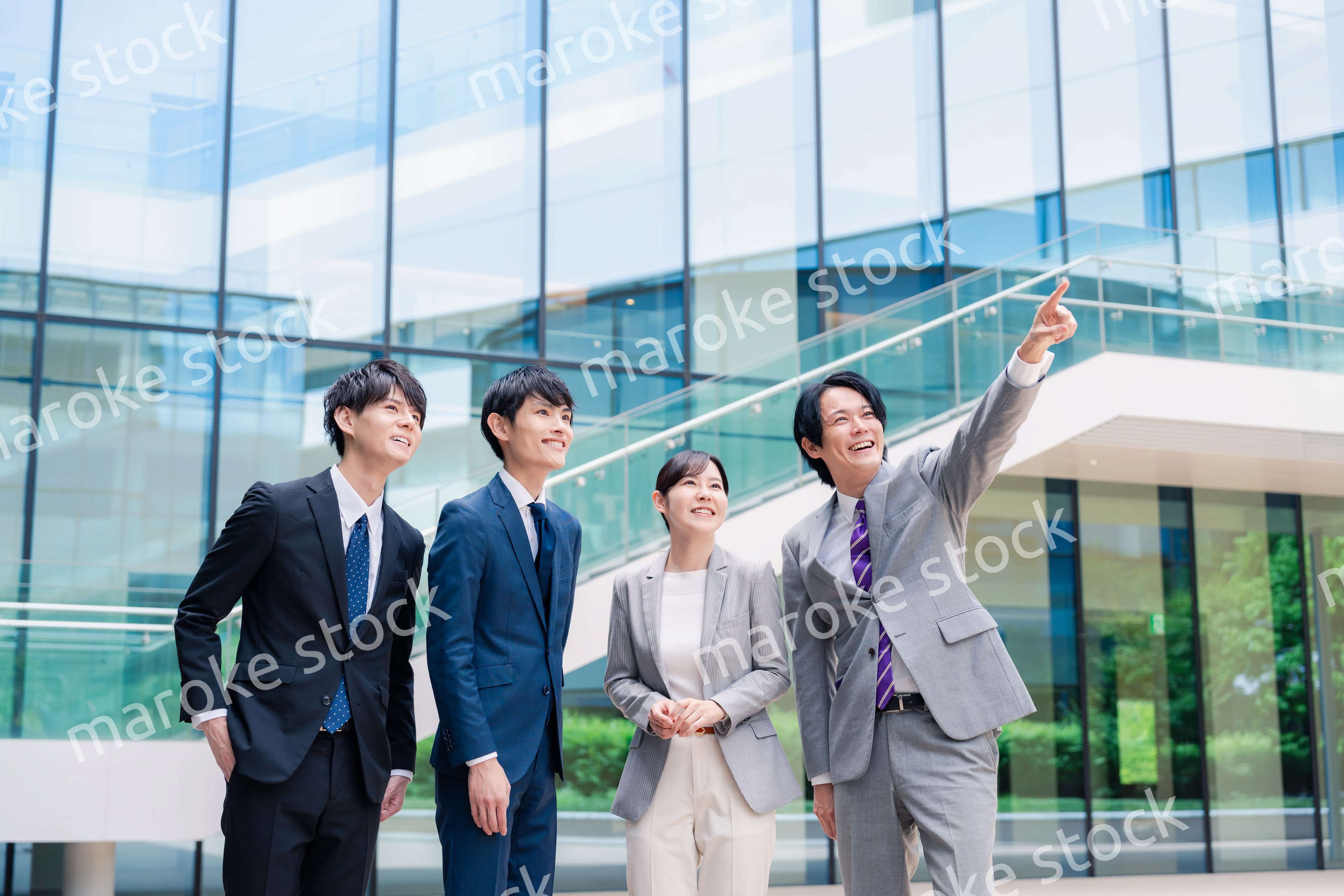 笑顔で未来を指差すビジネスパーソン