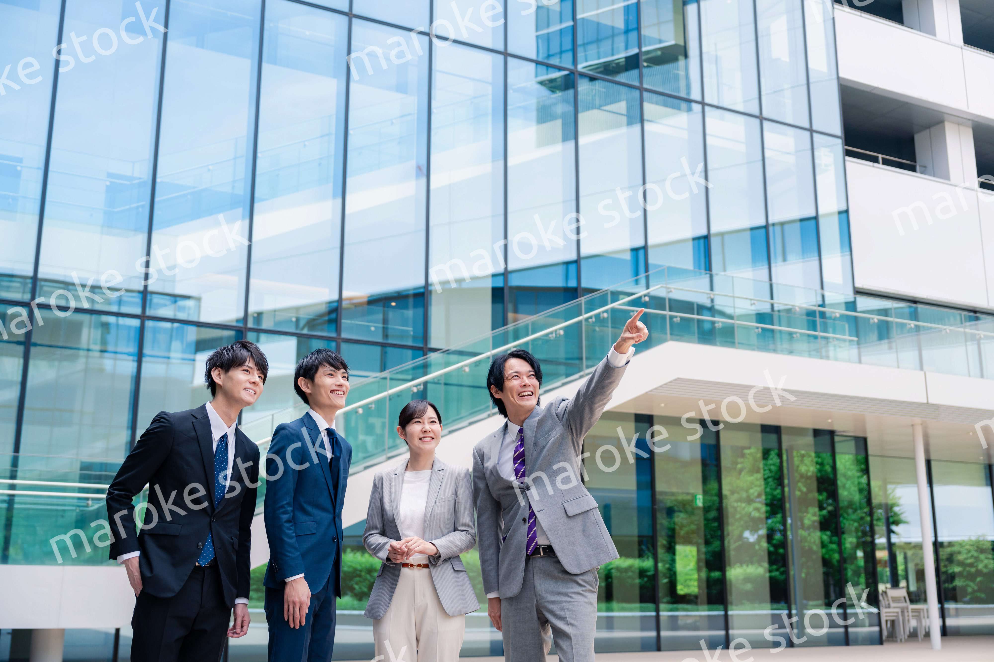 笑顔で未来を指差すビジネスパーソン