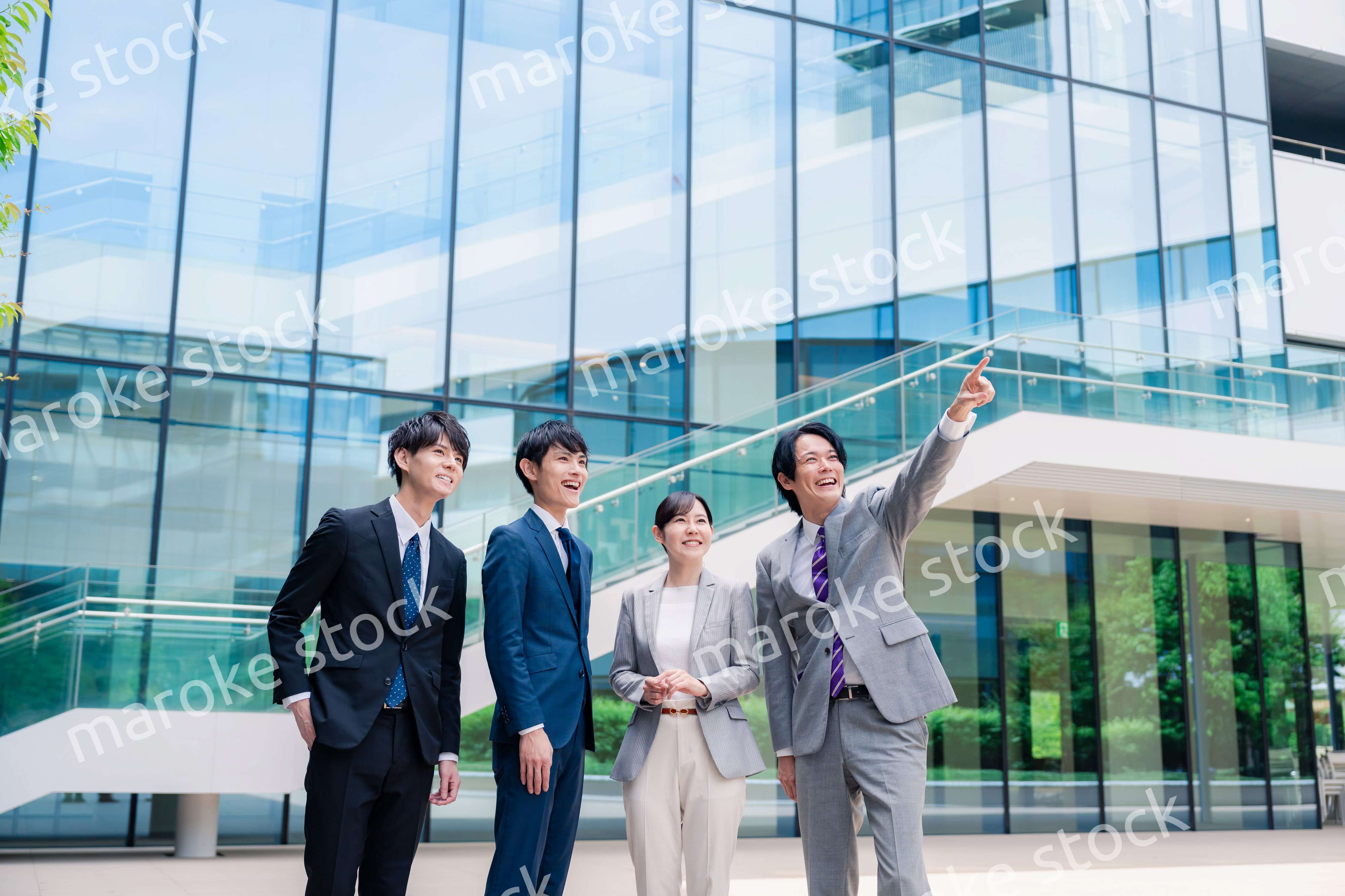 笑顔で未来を指差すビジネスパーソン