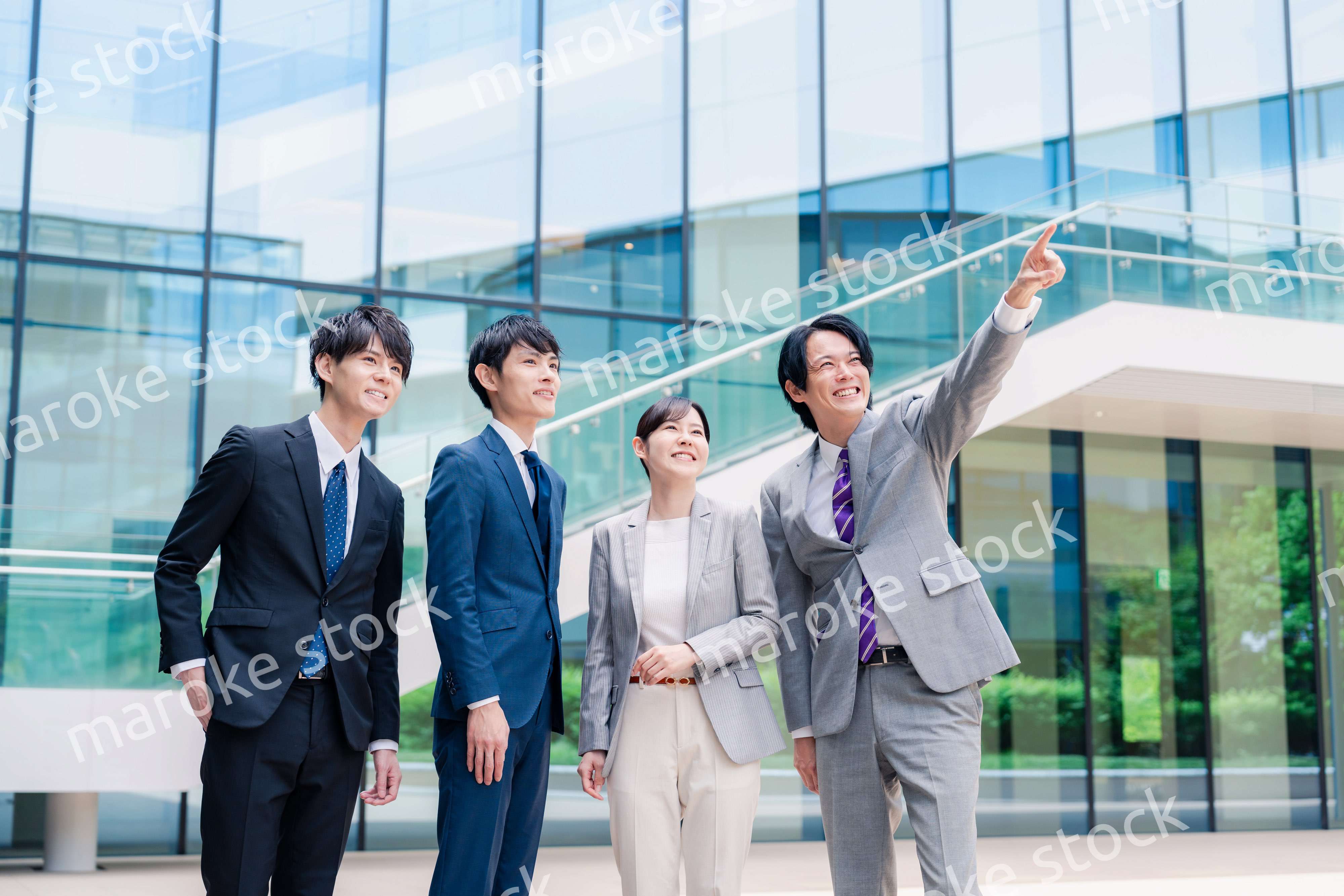 笑顔で未来を指差すビジネスパーソン