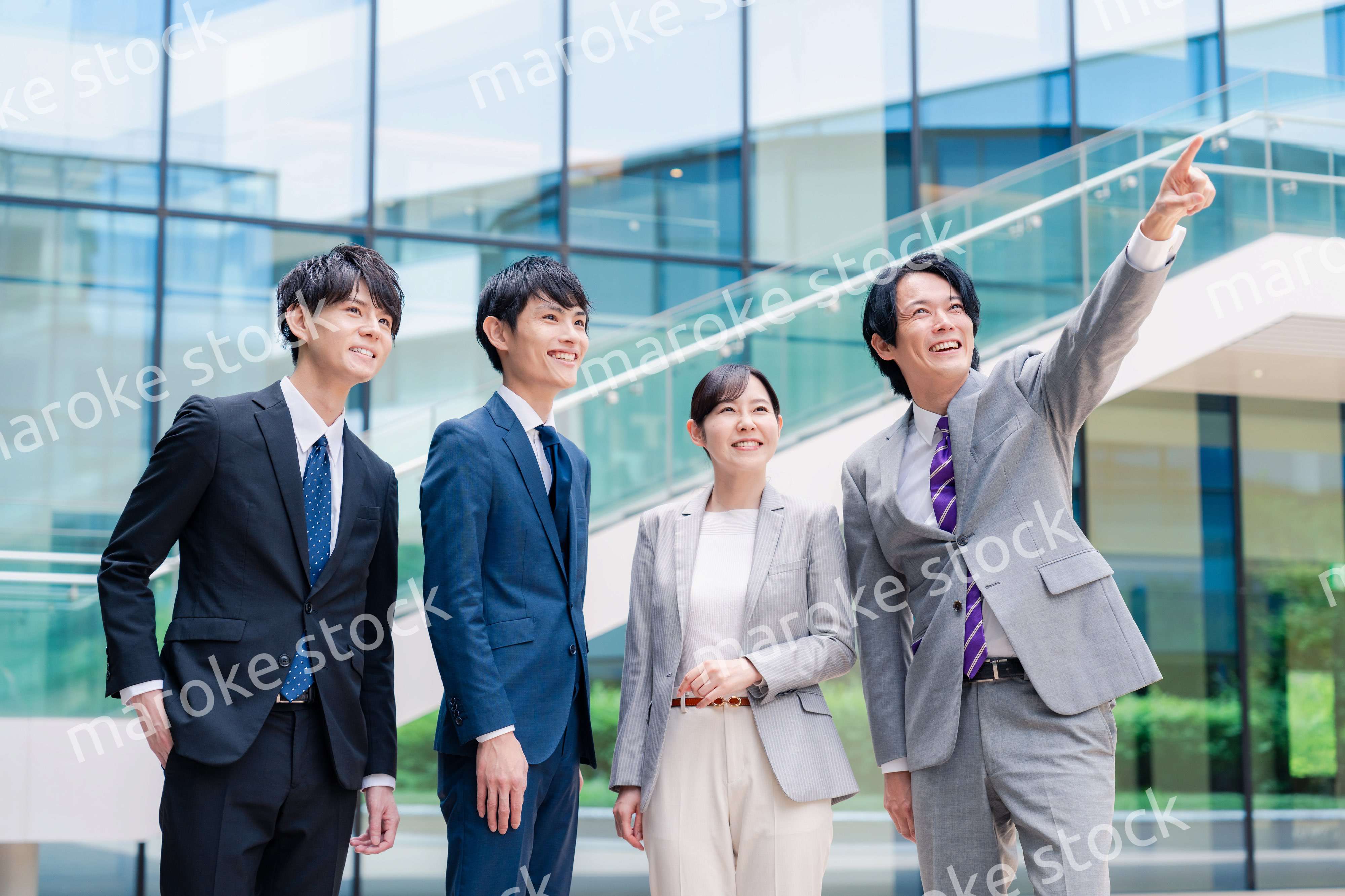 笑顔で未来を指差すビジネスパーソン