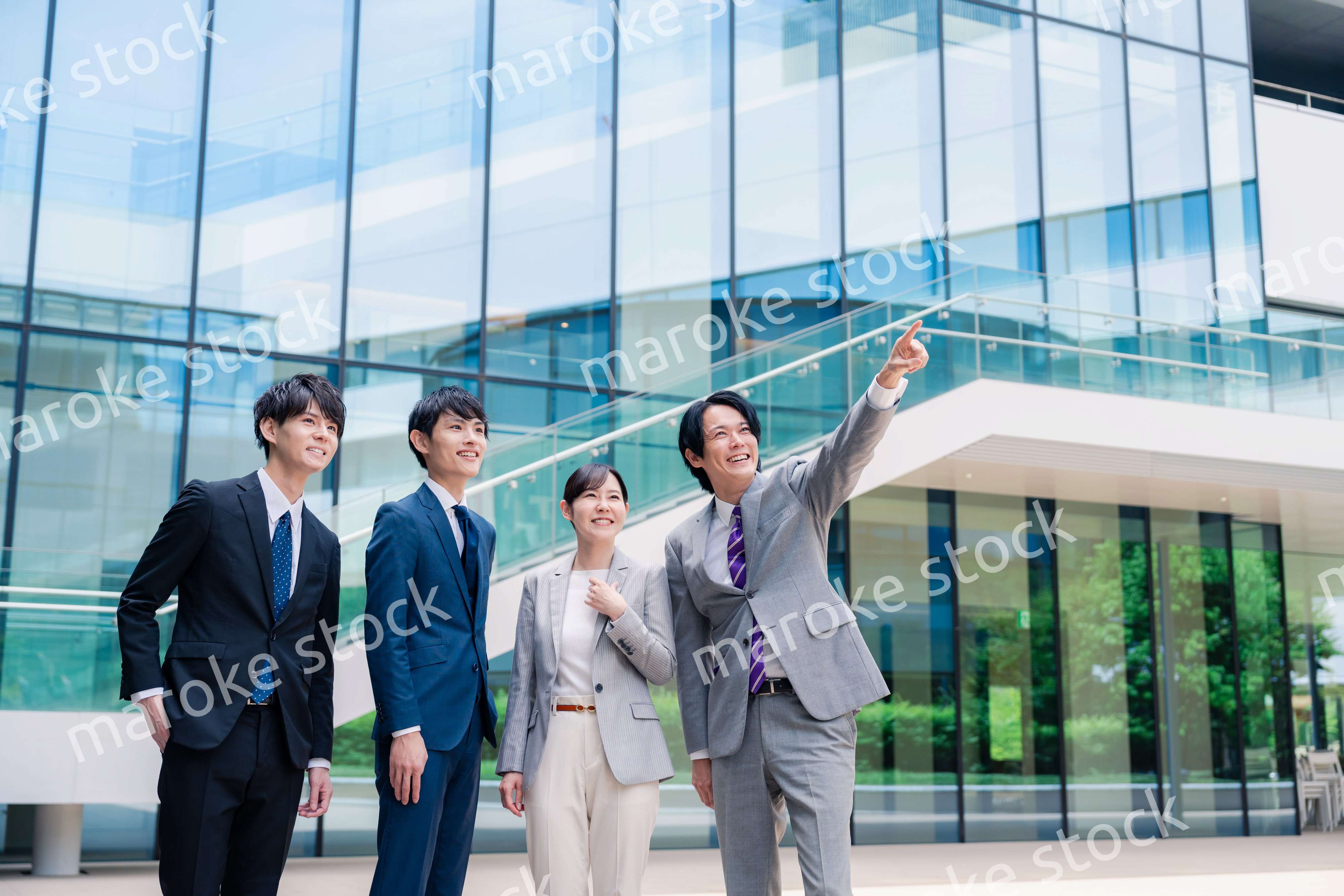 笑顔で未来を指差すビジネスパーソン