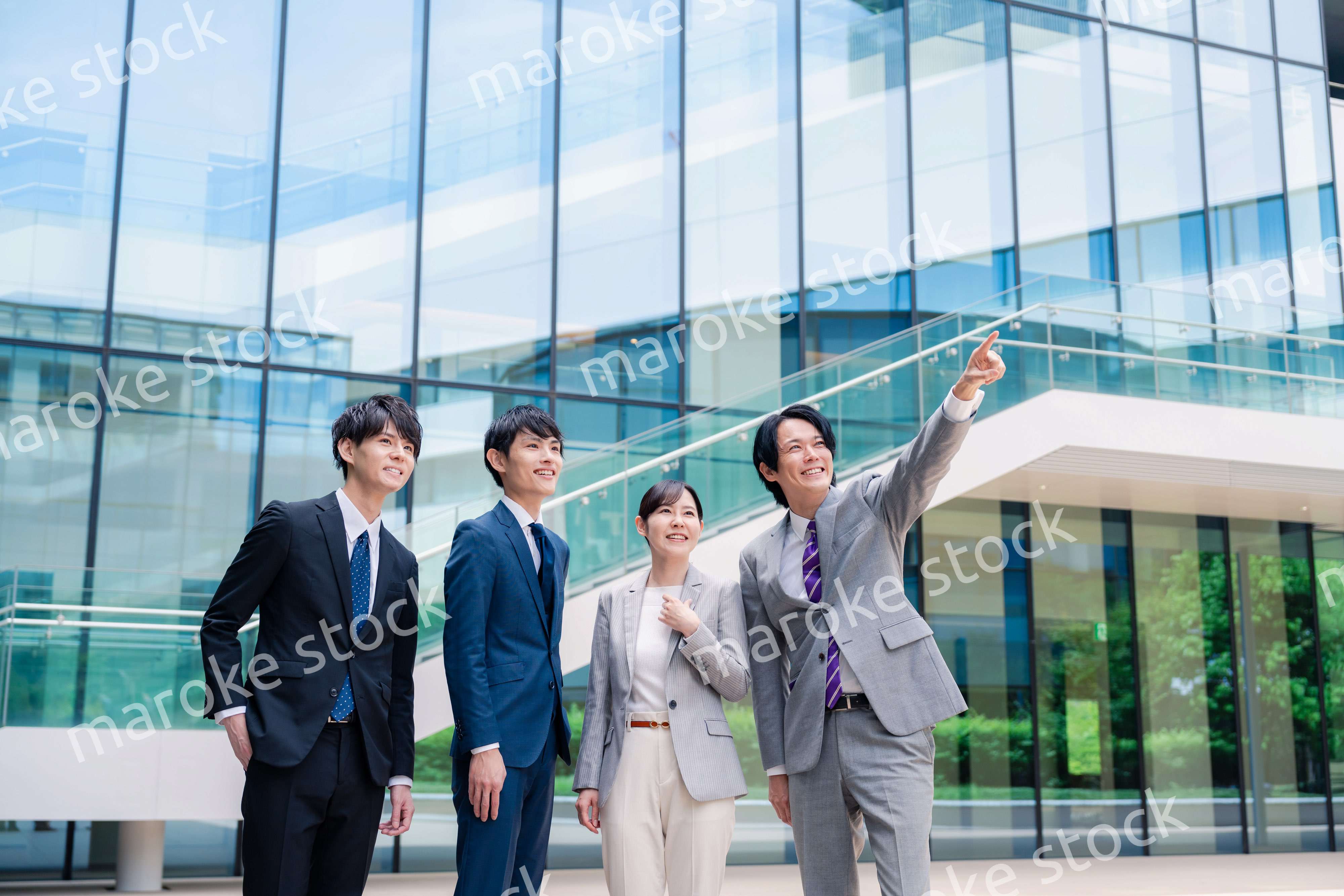 笑顔で未来を指差すビジネスパーソン