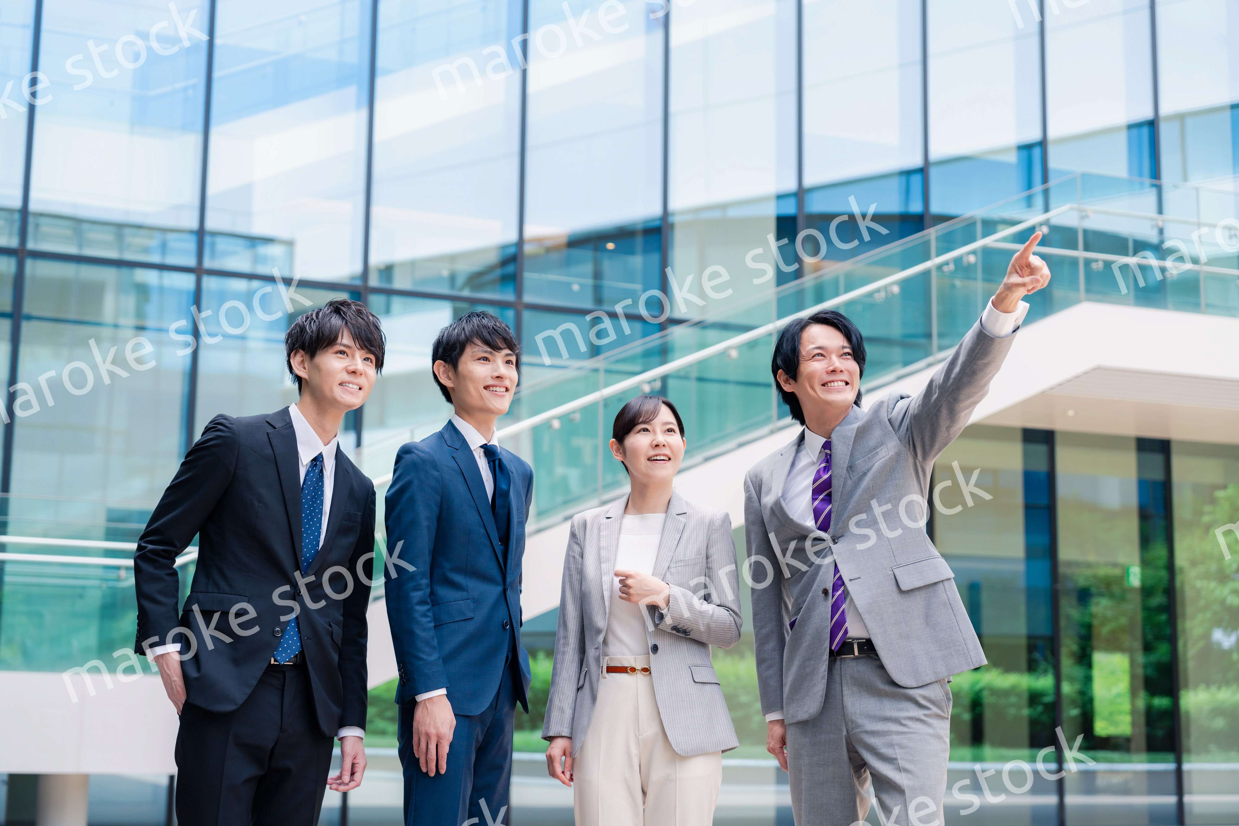 笑顔で未来を指差すビジネスパーソン