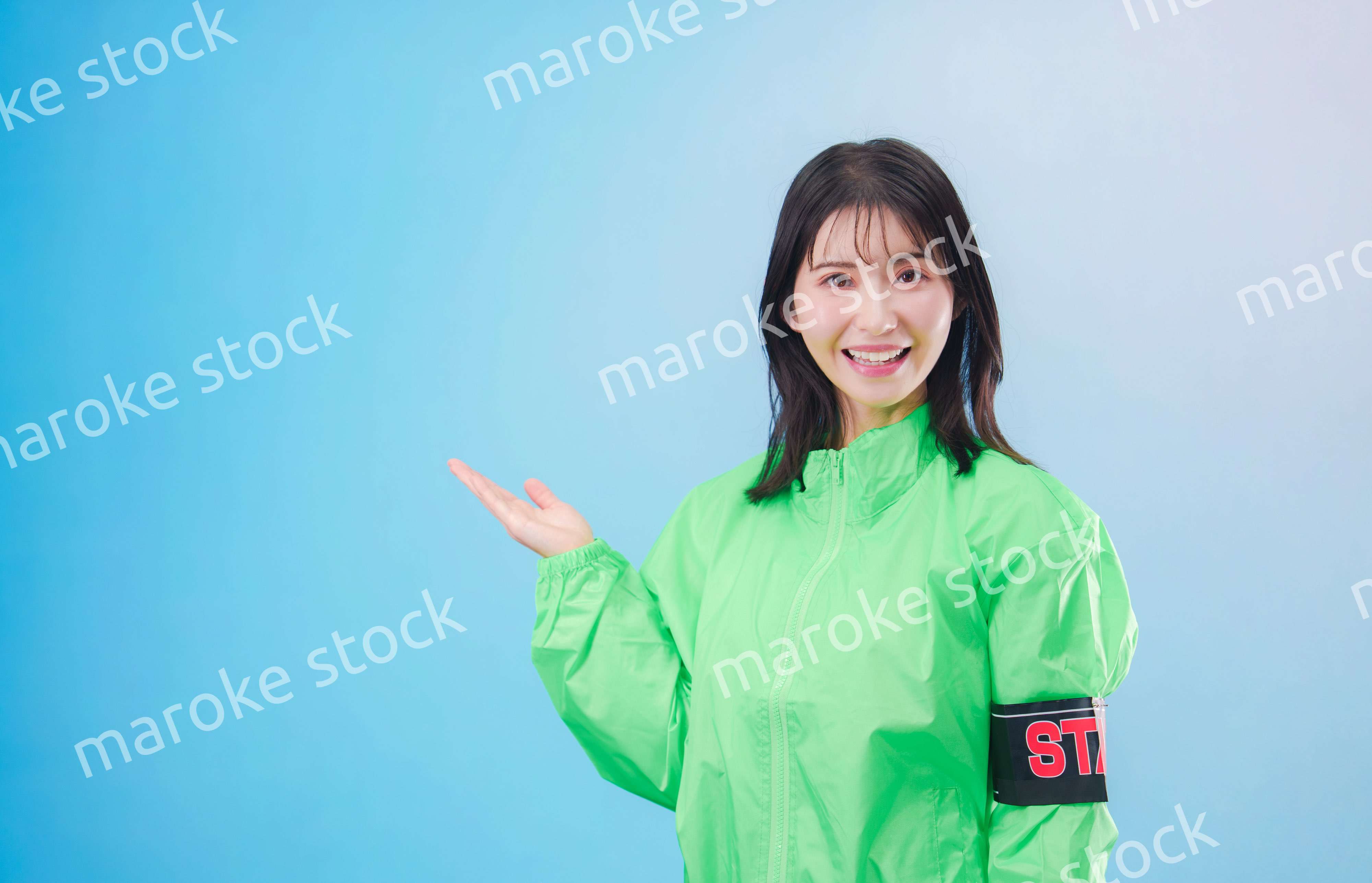 笑顔でお客様を案内するイベントスタッフ（水色背景）