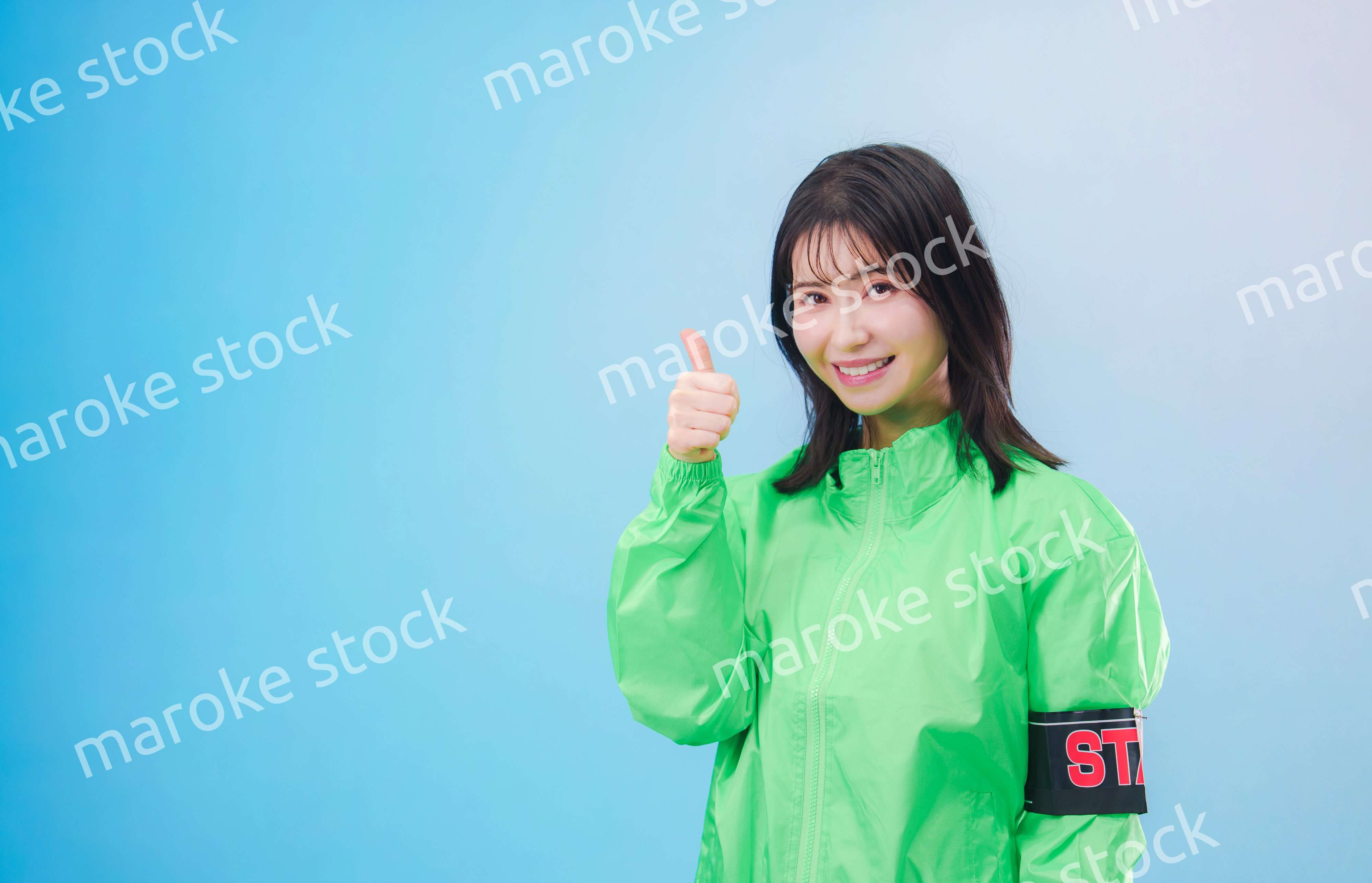 笑顔でお客様を案内するイベントスタッフ（水色背景）