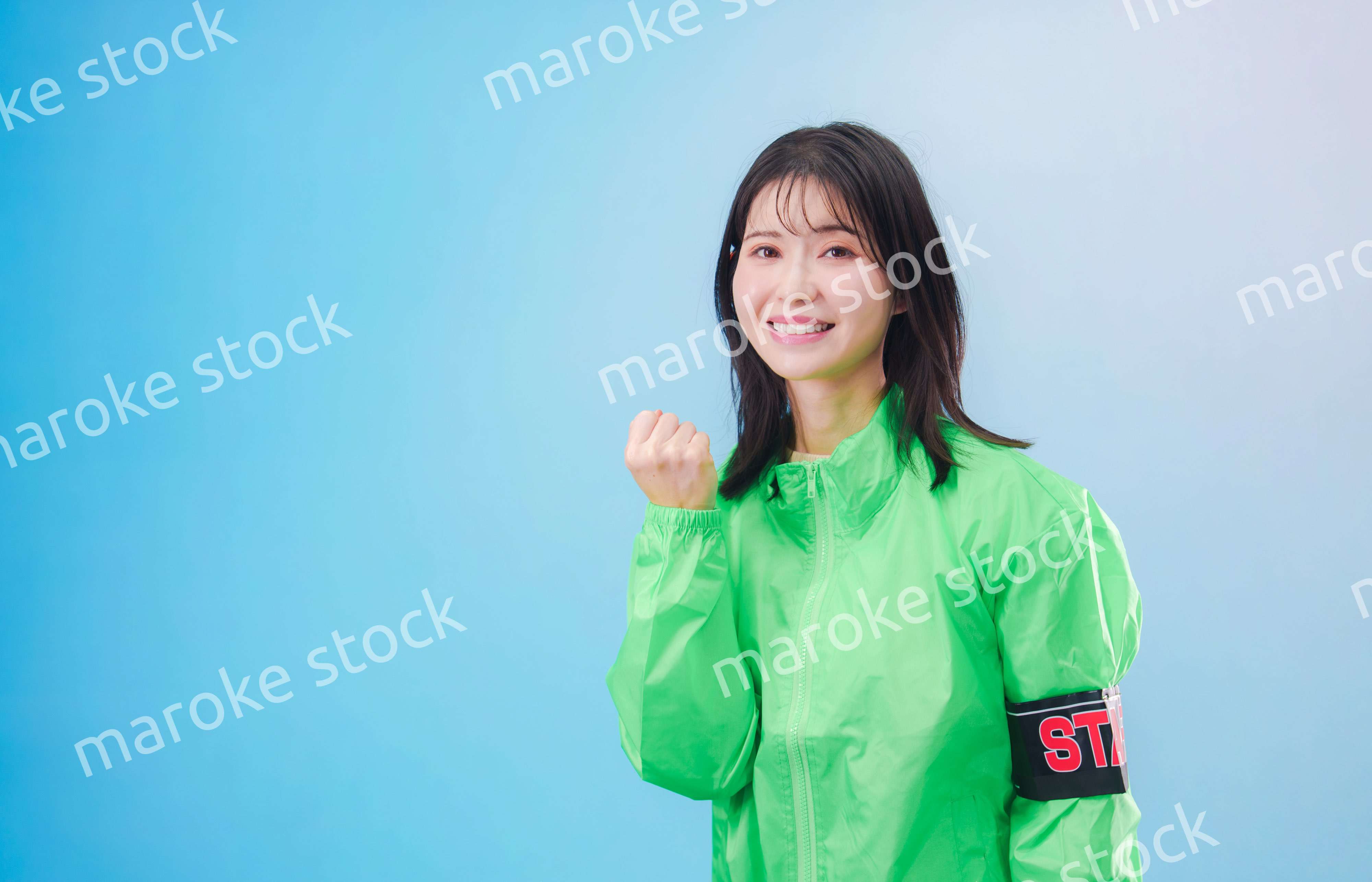 笑顔でお客様を案内するイベントスタッフ（水色背景）