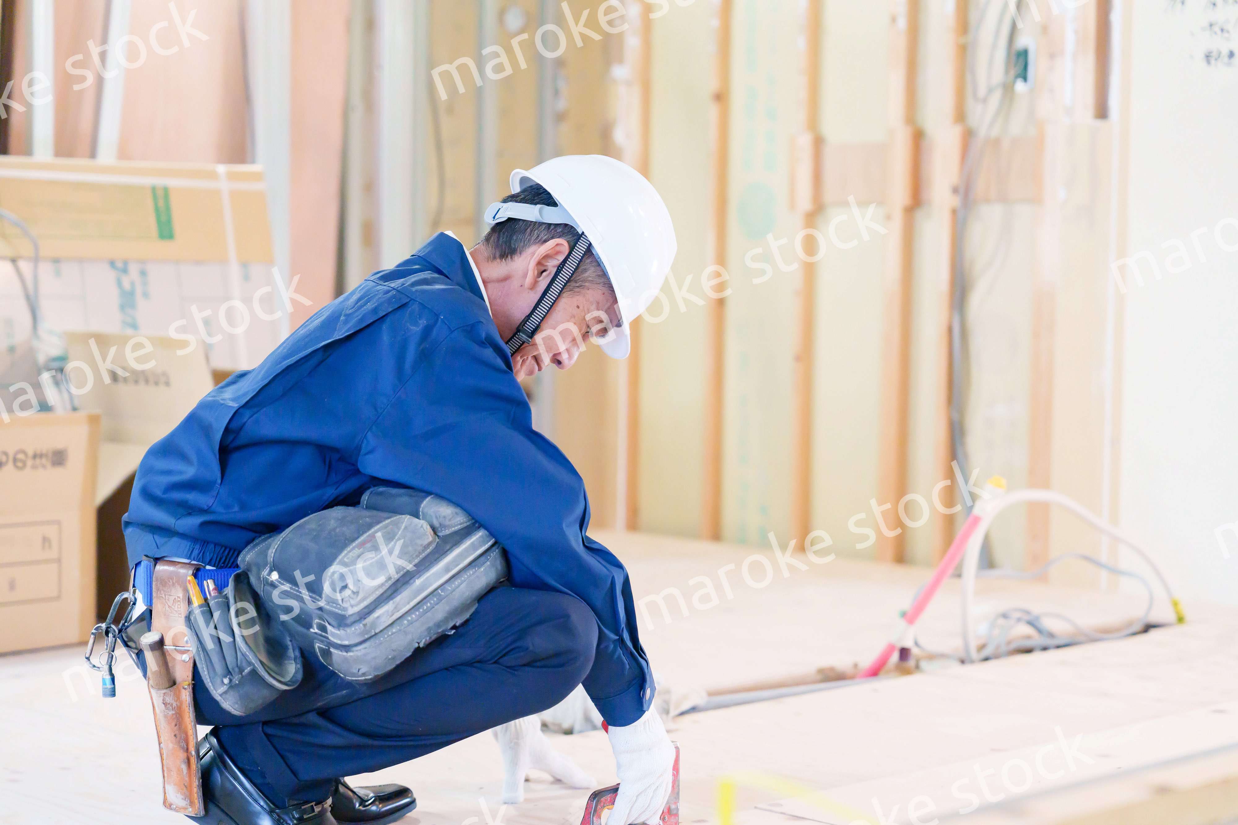 タッカーで建築資材を固定する男性の職人